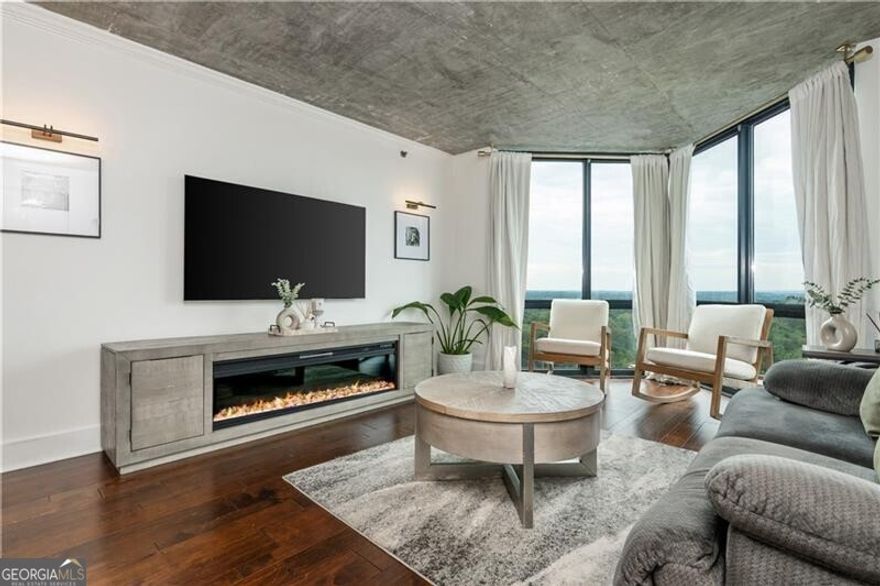 A true standout at The Concorde, this one-of-a-kind one bedroom residence redefines what condo living in Buckhead can be. Thoughtfully redesigned with a modern open concept layout, this home is the only 1-BR unit in the building to feature a full kitchen island, creating a seamless flow between cooking, dining, and entertaining. The kitchen itself is a showpiece, with dual tone shaker cabinetry, sleek hardware, open wood shelving, a subway tile backsplash, a built-in wine fridge, and elevated light fixtures that add warmth and sophistication to the space. The exposed concrete ceilings with visible ductwork give the home an industrial edge that feels both modern and authentic, something rarely found in this building. The bright and airy living room is framed by floor to ceiling windows showcasing one of the most desirable views in The Concorde, a sweeping west facing panorama over Buckhead's lush tree canopy that glows at sunset. The spacious bedroom enjoys the same natural light and skyline views, complemented by a large walk-in closet and beautiful hardwood floors that run throughout the home. The renovated bathroom features a walk-in subway tile shower, designer floor tile, and striking gold hardware that ties the space together with timeless style. Additional highlights include in-unit laundry with a washer and dryer, elevated lighting throughout, and thoughtfully designed storage solutions. Residents of The Concorde enjoy 24 hour concierge service, a resort style pool, tennis courts, a state of the art fitness center, a private dog park, and secure gated parking, all in one of Buckhead's most convenient and walkable locations just moments from the Shops of Buckhead, Whole Foods, and some of Atlanta's best dining and nightlife. With its distinctive layout, designer finishes, and incredible west facing views, this condo represents a rare opportunity to own a truly unique home in one of Buckhead's most established high rises.