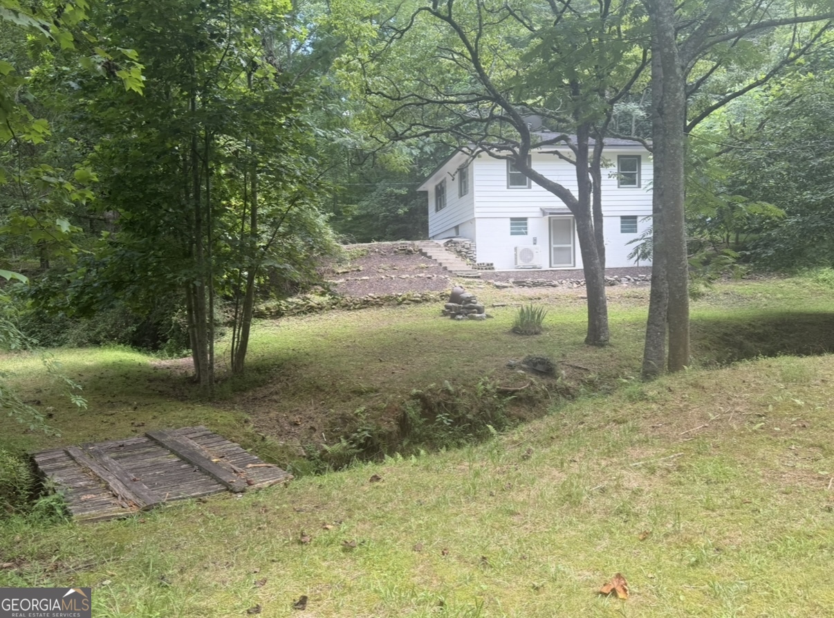 Fully Remodeled Mountain Retreat with Income Potential on almost 9 acres! Looking for a move-in ready home with space, versatility, and income opportunities? Welcome to this beautifully renovated 2-bedroom, 1 bathroom sanctuary in the heart of North Georgia wine country. Set on a serene, unrestricted parcel with a flowing creek that winds around the property offering charm, comfort, and flexibility-with short-term rental use possible. The extra unfinished space in the basement is perfect for office, gym, game room, workshop or extra sleeping area. The home has undergone a complete transformation, including: New flooring, drywall, doors, interior/exterior paint, remodeled kitchen with new cabinets, butcher block countertops, stainless steel appliances, and updated lighting and backsplash. The bathroom has a newly tiled shower, new vanity and fixtures. A new three-zone ductless heating & air system has been installed for the main level. Outside, there are 2 nice patio areas, and the yard opens to a spacious level area perfect for a huge garden, hosting around a fire pit, or even adding a pool. There is so much land to explore! The small outbuilding could serve multiple uses, and the carport will come in handy. The sprawling 8.76-acre lot includes at least one more building site-ideal for constructing another home or subdividing and selling a portion of the land off. With no deed restrictions and the ability to generate rental income, this property caters to so many buyers. Great for full-time living, vacation getaways, family compounds or investment potential. The location is great as it's just minutes from the charm of Helen, local wineries, and mountain trails!