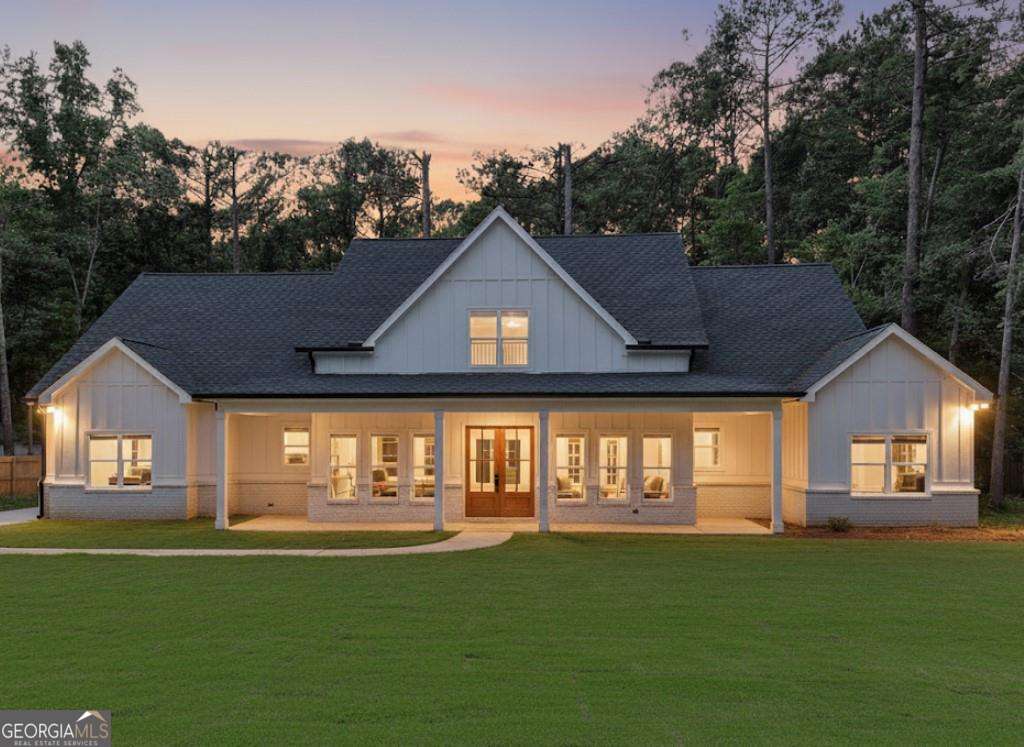 Stunning New Construction on 2.94 Acres Just Minutes from Downtown Monroe. Experience luxury living with this beautifully crafted home featuring 10-foot ceilings, 8-foot doors, and gorgeous hardwood floors throughout. The spacious family room is a showstopper with a 12-foot sliding glass door that opens to a covered back porch-perfect for indoor-outdoor living. The chef's kitchen is equipped with a massive quartz waterfall island, sleek stainless steel appliances, white cabinetry, and an oversized walk-in pantry. Enjoy elegant entertaining in the formal dining room and relax in the expansive great room. A mudroom and a laundry room with a built-in sink add everyday convenience. The primary suite is a true retreat with a tray ceiling, a spa-like bath including a soaking tub, a glass-enclosed shower room, dual vanities, and a generous walk-in closet. Three additional bedrooms and two full bathrooms-each with quartz countertops-offer space and comfort for family or guests. With front and back covered porches and nearly 3 acres of land, this home offers the perfect blend of modern luxury and peaceful privacy.