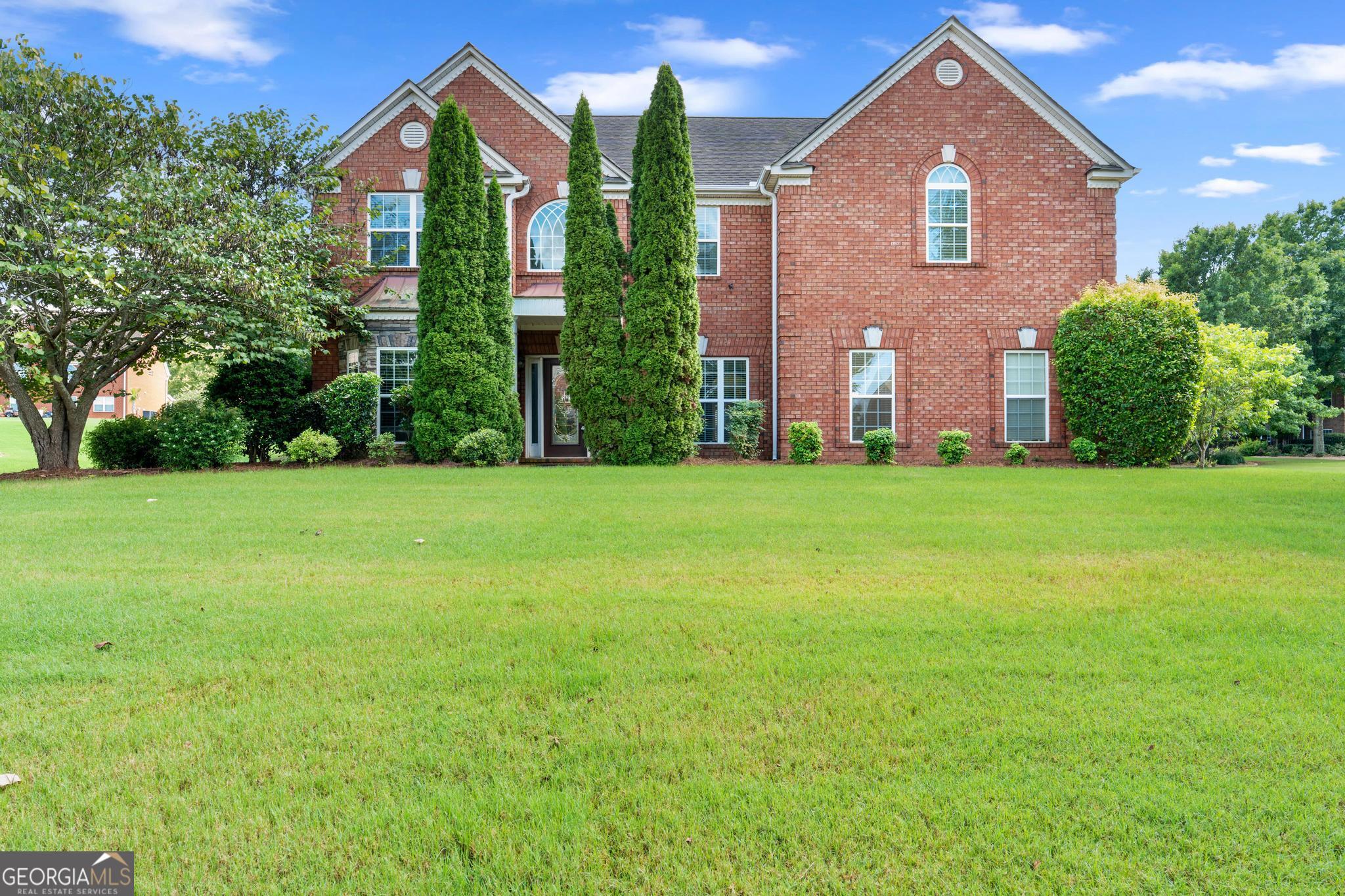 Welcome to this stately 4 bedroom, 2.5 bath home nestled behind the gates on a spacious corner lot in the prestigious gated community of Crystal Lakes. Known for its resort-style amenities, Crystal Lakes offers residents access to a premier golf course, clubhouse, swimming pool, tennis courts, a picturesque lake, playground, walking trails, and more-creating the perfect blend of luxury and lifestyle. This all-brick home is grand in both scale and style, featuring an attached two-car garage and a back patio ideal for outdoor gatherings. Step inside the soaring two-story foyer, flanked by a formal living room on one side and an elegant formal dining room with tray ceilings on the other. The heart of the home is the massive family room, complete with dramatic vaulted ceilings, abundant natural light, and a cozy fireplace. The kitchen is a dream-offering a walk-in pantry, center island, breakfast bar, breakfast area, and a keeping room that opens to the back patio, perfect for casual dining or entertaining. A convenient half bath completes the main level. Upstairs, all four bedrooms are generously sized and thoughtfully arranged for privacy. The oversized primary suite is a true retreat, featuring tray ceilings, double-door entry, and a luxurious en suite bath with dual vanities, a whirlpool tub, separate shower, and an expansive walk-in closet. The three secondary bedrooms share a well-appointed full bath and are ideal for family, guests, or flex use. A full laundry room with built-in cabinetry is also located on the upper level for added convenience. Don't miss this incredible opportunity to own a grand home behind the gates of one of Hampton's most sought-after communities!