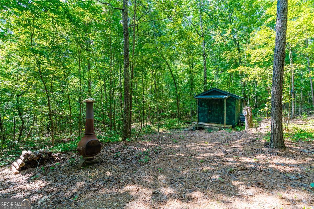 Nestled on 22.19 acres of serene natural beauty, this remarkable property offers the perfect blend of adventure and tranquility. Whether you're seeking a weekend escape or the ideal location for your future dream home, this land is ready for you. Explore an extensive ATV road system that winds through a mature hardwood forest, boasting mature trees that hold an estimated $50,000 worth of timber. Each boundary is clearly posted for your peace of mind. A spring-fed creek meanders across the front, adding to the property's natural charm. For your comfort, a cozy 12x16 cabin, built in 2022, provides a rustic retreat in a designated camp area. Solar security lights at both the gates and the cabin ensure safety and peace of mind. Outdoor enthusiasts will revel in the opportunities here. Enjoy a 100-yard shooting range and an abundance of wildlife, making this a true hunter's paradise. The top of the mountain is blanketed in wild blueberries, offering a unique and picturesque setting. With approximately 500 feet of road frontage, this property is not only a nature lover's haven but also boasts an unbeatable location. It's just 12 minutes from downtown Rome, 15 minutes from I-75 Adairsville, 20 minutes from Calhoun, and a mere 8 minutes from Barnsley Resort. Plus, you're only 5 minutes from Hwy 53 and Hwy 140. This is truly location, location, location! A successful perc test is in hand, making your building plans even easier. A secure parking area can accommodate up to 4-5 vehicles, ensuring plenty of space for guests and equipment. Don't miss the opportunity to own this versatile and stunning piece of Georgia.