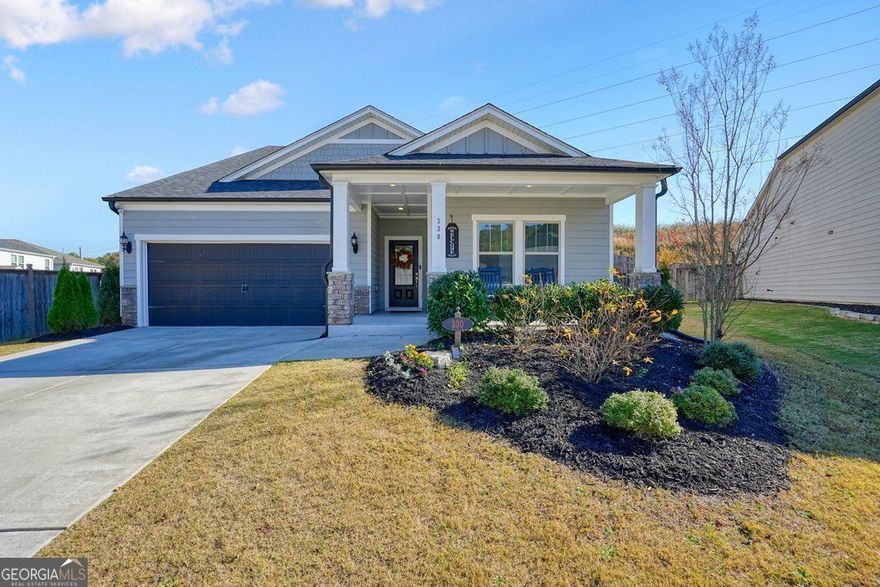 Welcome to 330 Davis Lane-a bright, stylish 4 bed / 3 bath 11/2-story ranch that mixes modern charm with that "feel-good" flow everyone is looking for. Built in 2020 and beautifully maintained, this 2,535-sq-ft home offers the perfect blend of comfort, space, and personality. Step inside and you're greeted by an open-concept layout that invites you to breathe, relax, and start imagining life here. The primary bedroom on the main level makes everyday living a breeze, while additional bedrooms and bonus space upstairs are perfect for guests, hobbies, or that home office you've been dreaming about. But let's talk about the showstopper-the kitchen. With sleek shaker cabinets, stone countertops, a large island, and a stylish backsplash tying the whole look together, this space is begging for potlucks, pancake mornings, and late-night conversations. The kitchen bar keeps everyone close to the action, while the layout makes hosting effortless. The living room brings the cozy with a charming fireplace, ideal for unwinding after a long day or creating your next movie-night ritual. Tray ceilings in the primary bedroom add an extra touch of elegance, and the welcoming front porch is practically made for coffee sipping, neighbor waving, and enjoying those perfect Georgia evenings. And the location? Perfection. You're just 10 minutes from Downtown Woodstock-hello, great food, live music, and small-town charm! Plus, Dupree Park is right around the corner for nature walks, playtime, and weekend fun.  Modern comfort, warm character, and an unbeatable location-this Woodstock gem is one you'll definitely want to check out!