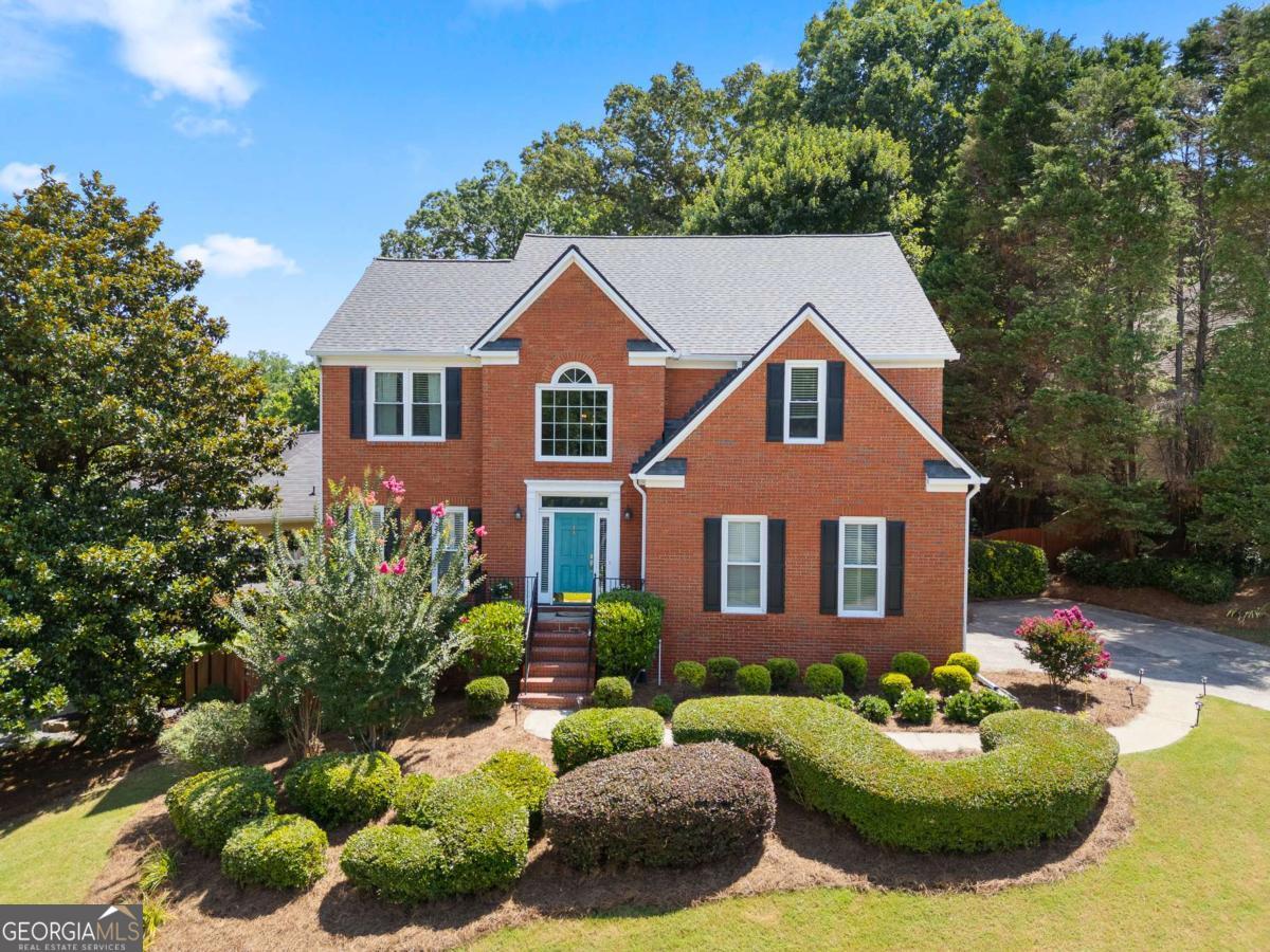 Welcome to 4059 Vinings Mill Trail - Located in the Sought-After Olde Vinings Mill Community. This beautiful, 5-bedroom, 3.5-bath home sits on a premium corner lot with stunning curb appeal, is just steps from community amenities including a pool, playground, and tennis courts. As you enter, you're welcomed by a two-story foyer and gleaming hardwood floors throughout the main level. The open-concept kitchen features granite countertops, a gas range, custom cabinetry, and an extended island overlooking the breakfast nook and spacious living room. Enjoy natural light from the wall of windows at the rear of the home, offering peaceful views of the lush, garden-style backyard. Additional main floor highlights include a formal dining room and a separate sitting room or flex space. Upstairs, the oversized primary suite includes a cozy reading nook, walk-in closet, and an updated en suite bath with double vanity and walk-in shower. Three additional bedrooms and a full bath offer flexible space for guests, children, or a home office. The fully finished basement is perfect for entertaining, relaxing, or multi-generational living. With a large bedroom, full bath, and walk-out access, it's ideal for an in-law suite. There's also a generous unfinished storage area. Perched on a gentle hill with a flat driveway, this home is conveniently walkable to Ivy Walk's shops and restaurants, close to the Silver Comet Trail, and just minutes from I-285 and I-75 for easy commuting. Don't miss this incredible opportunity - schedule your showing today!
