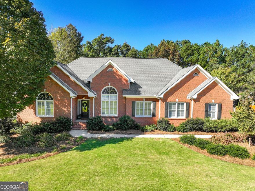 Welcome to this exceptionally well-maintained and thoughtfully updated 4 bedroom, 3.5 bathroom three-sided brick home located in the highly sought-after Lakehaven neighborhood - a premier community offering access to tennis courts, two swimming pools, and top-rated Union Grove schools. This beautiful property sits on a spacious, professionally landscaped lot with a WiFi-controlled irrigation system, an attached two-car garage, a separate basement-level garage, and a fully fenced backyard featuring a main-level deck, lower patio, and a custom stone firepit accented by LED path lighting - the perfect setup for outdoor living and entertaining. Inside, every detail reflects quality and care - from the gleaming hardwood floors throughout to the elegant two-piece crown and trim moulding and dimmable lighting in most rooms. The inviting foyer opens to a formal dining room on the right, showcasing high ceilings and abundant natural light. The family room strikes the perfect balance between grand and cozy with its tray ceilings and charming fireplace, creating an ideal space for gathering and relaxation. The kitchen is truly the heart of the home - professionally updated and designed for both style and function. It features stainless steel appliances, a custom vent hood, natural stone countertops, LED under-cabinet lighting, a breakfast bar, and a bright breakfast area. Just off the kitchen is a beautifully renovated laundry room with a granite countered sink and built-in storage as well as a convenient half bath. The oversized primary suite offers a tranquil retreat with tray ceilings, two walk-in closets, and a luxurious updated en suite bathroom complete with double vanities, a stand-alone soaking tub, and a walk-in shower. On the opposite side of the main level (in a desirable split-bedroom layout) are two additional spacious bedrooms with access to an updated full bath. The finished basement provides exceptional flexibility and could serve as a complete in-law suite. It includes a kitchenette, a comfortable living area, a private bedroom, and a full bath. Additionally, the lower level offers a separate office (which could function as a fifth bedroom), a walk-in storage room, and a 512 sq ft workshop - perfect for hobbies or projects. From its meticulously maintained interior to the beautifully designed outdoor spaces and resort-style neighborhood amenities, this Lakehaven home offers the perfect blend of comfort, craftsmanship, and convenience in one of the most desirable school districts in the area.