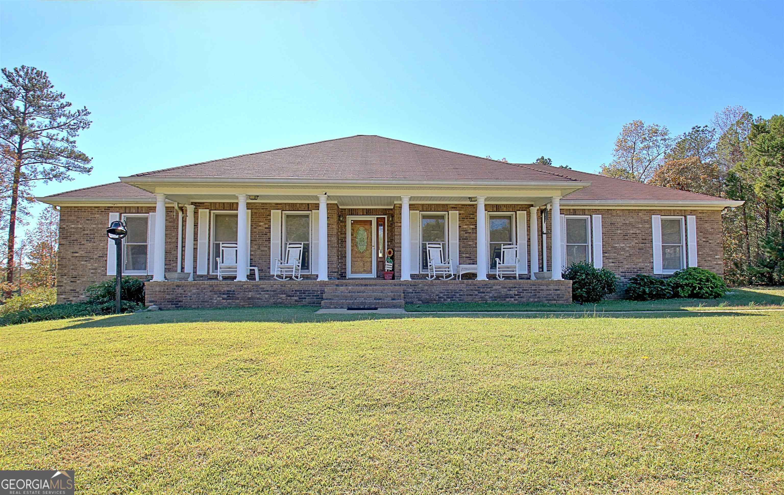 This 7-acre brick ranch on a pond is both private and close to everything. It is 7 minutes from charming downtown Newnan. With a Master-on-main floor plan, this 4 bed 3 bath consists of 3 bedrooms 2 baths on the main floor with stunning lake views from most rooms. A massive balcony/deck overlooks the water and the woods from this little paradise home. With 1 bed and 1 bath downstairs, the basement is equipped with its own entrance that walks out onto a porch below the upper balcony. This space has a very large main room with windows facing the water and could easily be renovated to have a small kitchen or cooking area. The Master suite is on main level and walks out to balcony and has large hers/his closets, spacious bathroom with soaking tub , separate vanities, and walk in shower. The garage opens into the kitchen for easy grocery access. The breakfast area looks out over the lake while the separate dining room provides formal dining for those occasions. The wide rocking chair front porch great for morning coffee that looks out onto the front lawn. This 4 sides brick gem on ~7.5 acres has a lake-front view from most rooms in the house, mostly finished basement that walks out to the lake, large storage area also in the basement, boat doors and garage for Polaris, 4-wheeler, or fishing boat. There is a separate workshop building with power and a metal shipping container for storage of mower or tractor. No HOA or deed restrictions. Close to downtown Newnan and the Square, Ashley Park Mall, stores, I-85 and 35 minutes from Hartsfield Airport. Call today to schedule a showing. JC 770-755-8507