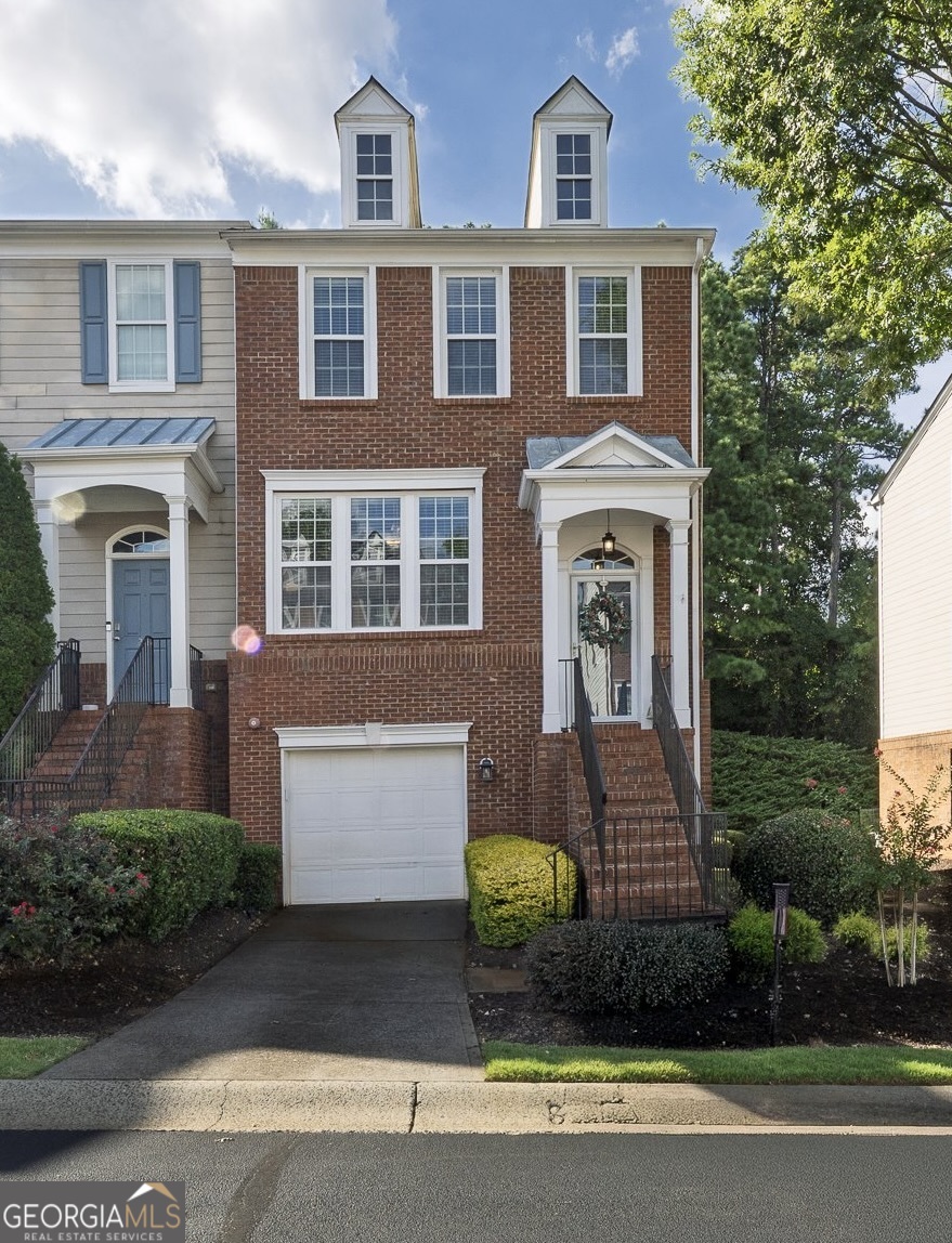 This beautiful end-unit townhome is located in the highly sought-after master-planned community, Woodlands. From the moment you enter the inviting foyer, it is clear that this home has been lovingly maintained. The main level boasts a light-filled family room with a cozy fireplace, a spacious kitchen with a center island offering seating, abundant cabinet and counter space, newer appliances, and a generous walk-in pantry that flows seamlessly into the dining area. Step outside to the private rear deck, complete with lights, where you can enjoy peaceful views of the wooded surroundings. A convenient half bath for guests completes this level. Upstairs, the primary suite offers a vaulted ceiling, a walk-in closet, and an ensuite bath with a double vanity. An additional bedroom and full bathroom are also located on this level, along with a conveniently placed laundry area between the bedrooms. The lower level offers a versatile bedroom that can easily serve as flex space, with direct access to the backyard and its own full bathroom. The garage includes a storage nook, providing extra space for organization. Residents of the Woodlands enjoy resort-style amenities, including two pools, ten tennis courts, pickleball, an expansive playground, basketball courts, sand volleyball, a clubhouse for gatherings, and miles of nature trails throughout the community, with future plans to connect to the new Little River Park nearby. The neighborhood hosts a variety of events throughout the year and is located within an award-winning school district. The location is ideal, with direct access to Hwy 92 for a quick drive to Downtown Woodstock's shopping, dining, and entertainment, or an easy trip into Roswell and East Cobb for even more options. Commuters will also appreciate the close proximity to I-575. Come experience why Woodlands is one of the most desirable communities in the area and discover the lifestyle you've been looking for. Please refer to the features sheet online for additional information regarding this beautiful property.