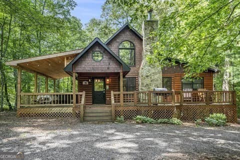 Welcome to your perfect mountain retreat! Whether you're seeking a charming new home, a cozy second home, or an ideal cabin for vacation rentals, this beautifully maintained 3-bed, 3-bath, fully furnished cabin is ready to welcome you. This cabin has brand new upgrades - a roof (2023), a tankless water heater (2024). Everything is move-in ready for you to start enjoying the beauty and tranquility of the mountains right away. Step into this delightful, well-kept cabin, nestled in the serene Cool Waters of Wolf Creek community - and with NO HOA! As you wind up the tree-lined driveway, you'll be greeted by a beautifully landscaped front yard and a charming front porch that's ideal for your morning coffee or relaxing at the end of the day. Inside, you're greeted by an open, light-filled living space with large windows that bring the outdoors in. The cozy gas log fireplace adds the perfect touch of warmth and ambiance without the mess. The adjacent dining area, complete with a rustic Live Edge Farm table, is the ideal spot for family meals or entertaining. The kitchen, featuring modern appliances and sleek granite countertops, flows seamlessly into the living and dining areas for effortless entertaining. The main level offers a spacious master bedroom with an en-suite bath, a second bedroom and bath, and convenient main-level laundry. Upstairs, kids and guests will love the entertainment area and the third bedroom with its own en-suite bath. Enjoy the rich beauty of hardwood floors in the living, dining, and kitchen areas, with luxury vinyl plank in the bedrooms and bathrooms for a modern touch. Step outside and unwind by the fire pit, soak in the hot tub, or relax on the porch as you take in the peaceful surroundings. This cabin is perfectly located just minutes from McCaysville and Copperhill, with easy access to Blue Ridge, Morganton, Blairsville, and Ellijay - offering endless opportunities for shopping, dining, hiking, biking, boating, and more. Don't miss out on this exceptional opportunity - your dream cabin awaits!