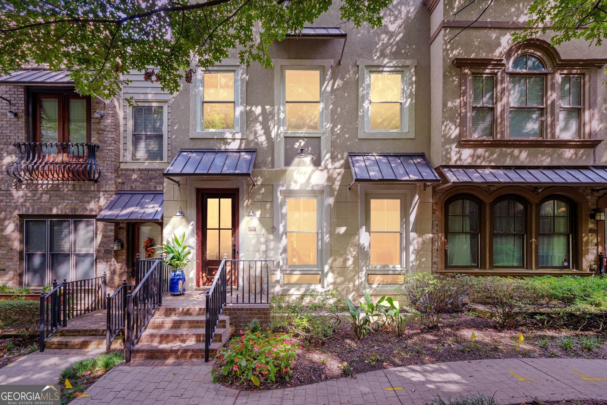 Experience City Living in this Elegant Midtown Townhome tucked within an Intimate Enclave of European-Inspired residences and Tree-Lined Sidewalks. The Open Floor Plan spans three levels with hardwoods throughout, featuring 2 Bedrooms, 2 Full Baths, 2 Half Baths, and a Versatile Den. Sun-Filled Living and Dining areas include Custom Built-Ins, while the Chef's Kitchen boasts a Granite Island, Stainless Steel Appliances, 5-burner Gas Cooktop, Pantry, and access to a Covered Deck perfect for morning coffee or evening gatherings. Upstairs, Two Bedroom Suites each include Walk-In Closets and Spa-Like Baths. The Lower Level offers a Flexible Den with Half Bath that could easily serve as an office, a Third Bedroom, TV Room or Home Gym. Parking is simple and easy with Driveway Parking and a 2-Car Garage recently upgraded with Non-Slip Premier Floors. No Rental Restrictions offer excellent flexibility. Enjoy one of the most private settings in the community, all just a short stroll to Atlantic Station's shops, restaurants, grocery, GA Tech, and year-round events or hop on the free shuttle to MARTA and explore everything Atlanta has to offer. This home blends privacy, style, and unbeatable convenience in one exceptional package.