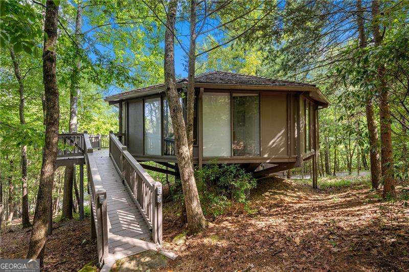 Your opportunity to own a Charming Chalet in one of North Georgia's most desirable mountain communities. Two Bedroom Two Bath Updated and ready for New Owners. Gorgeous Hardwood Flooring. Tongue and Groove Ceiling accented by Exquisite Exposed Beams add a Touch of Elegance. Wall of Windows and Peaceful Paint Colors bring Nature inside to create a True Sanctuary. Cozy Stone Fireplace for cool Fall and Winter Days. You will love the Expansive Wraparound Deck! Perfect location in the Treetopper section of Big Canoe Ultra Convenient to Amenities and Main Gate. This 8000 Acre Private Gated Community offers world class amenities including Golf, Tennis, Pickleball, Scenic Hiking Trails, Three Lakes, Boating, Fishing, Fitness Center, Indoor/Outdoor Pools, Clubhouse, Restaurants and more. While there is a lot to do at Big Canoe, there is so much more to enjoy just outside the gates of Big Canoe. Gibbs Garden a Destination Garden. Ball Ground offers Feather's Edge Vineyards, Rock Solid Brewing and Art Galleries. Poole's Mill Historic Covered Bridge a Passive Park with Playground, Picnic Tables, and views of Settendown Creek. Annual Festivals and so much more for fun year around! A wonderful opportunity for your Private Getaway or as a Short-Term Vacation Rental. Approximate one hour drive from the Atlanta Metro Area. Schedule Your Viewing Today!