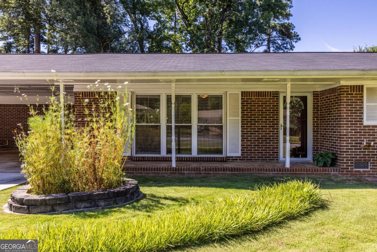 Welcome home to this charming 4-sided brick ranch on a beautiful .4-acre, sun-filled level lot in Tucker. Ideal for garden enthusiasts or woodworking hobbyists, this property features established raised garden beds, a greenhouse, a powered and lit workshop, plus a large storage shed. There is plenty of space for play, pets, and additional landscaping. A covered patio provides a great spot for outdoor dining and relaxing year-round. Inside, you will find newly refinished hardwood floors and fresh interior paint throughout, offering a clean slate to move right in and update at your own pace. Additional improvements include a new driveway, roof and gutters (2020), HVAC (2021), water heater and interior plumbing lines (2019), plus energy-efficient double-pane windows. Located just minutes from Tucker's vibrant Main Street with local shops, restaurants, and popular community farmers market. This well loved home offers a wonderful opportunity for anyone looking for low maintenance, one level living at an affordable price.