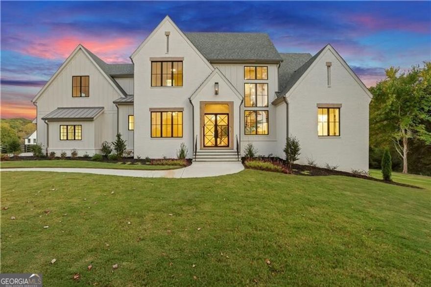 An incredible new price creates an exceptional opportunity to own this custom-built estate in a premier Canton location on 2+ acres!  Dramatic custom glass entry doors open to a show-stopping three-level staircase, 7" wide-plank white oak floors, and soaring vaulted ceilings. The heart of the home features a limestone fireplace and seamless indoor-outdoor living, with 12' accordion doors that open to expansive beamed porches overlooking the private estate. The chef's kitchen includes Thermador appliances, custom cabinetry, stunning oversized quartzite waterfall island with seating, a mix of natural wood tones, and Brizo Litze fixtures. A separate scullery features an arched entryway, showcasing Bardiglio and Carrara marble checkered floors, caf -style drawer dishwasher, black fireclay farmhouse sink, and designer hardware. The custom details like the reeded Calacatta Viola marble floating 54" sink basin and designer lighting add luxurious sophistication to the adjacent bath. The main-floor owner's suite impresses with a beamed ceiling, private veranda, and a spa-worthy bath featuring heated herringbone marble floors, a zero-entry shower, and stunning vanities. Upstairs, four spacious en-suite bedrooms offer comfort and style, while the terrace level is designed for entertaining with a sleek micro-shaker bar, media space, and access to a flat, POOL READY backyard. Bevolo gas lanterns, custom corbels, and Pella Aluminum Clad Casement windows lend timeless character to the exterior. With high-performance windows, foam insulation, a Ruud HVAC system, and smart prewiring throughout, this home blends modern technology with enduring craftsmanship-just minutes from Milton and downtown Alpharetta, with the added benefit of Cherokee County taxes. Preferred Lender offering a $6K credit to be applied toward closing costs, prepaid items, or an interest rate buydown, subject to approval.