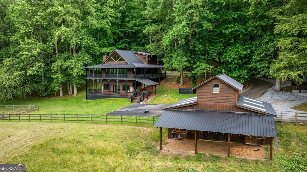 Discover the tranquility and privacy on this breathtaking property situated on 19.22 acres on the Cohutta Ranch. As you enter the home you will find a welcoming open floor plan that seamlessly connect the living room, dining space & kitchen. This completely updated Cabin with just under 3000 sf of living includes 3 spacious bedrooms, each featuring its own private bathroom for ultimate comfort and privacy. Luxury modern style master bath on main offers tiled shower with bath enclosed, double vessel styled vanities and granite counters. Large walk in closets in all bedrooms. The beautiful features include vaulted ceilings, gorgeous floor to ceiling stone fireplace and beautiful wood flooring. Enjoy cooking for your guest in your amazing kitchen offering granite countertops and stainless appliances. The living room offers full wall of opening doors flooding the home with natural light & gorgeous views of your property. The living areas create a cozy and inviting ambiance, perfect for relaxation and gatherings. The fully finished basement is a great entertaining area with laundry room and office area or your own private library. Wrap around porches on every level allow you to take in the days of mountain air offering mountain views of the picturesque pond or the meandering creek frontage or watching the stars by your firepit. This property also has 2 spring heads. This peaceful equestrian property features 5 lush fenced paddocks and fabulous 3 stall center aisle barn with office and detached 2 car garage. Community offers additional barn for boarding, fire pit, pavilion for cookouts & walking trails. It also borders the US forestry. Do not miss the chance to make an amazing farm property your own.