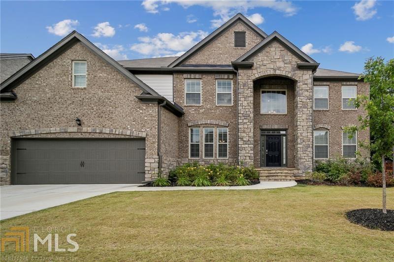 One of a kind architecturally designed three side brick home located minutes from I-985, Mall of GA, downtown Buford, and Buford City Schools. Two story stone entry. Elegant two story foyer and side front staircase with iron balusters. Separate dining room with coffered ceiling. Two story family room with ceiling to floor stacked stone fireplace, stone hearth, built-in shelves, and cabinets. Double bay window. Gourmet kitchen opens to cozy keeping room with stacked stone fireplace, separate eat-in area, back staircase, built-in shelves and bookcases. Quartz countertops, island with sink, stainless steel appliances, designer tile backsplash, and double ovens.Newly added covered screen porch with stacked stone fireplace and cedar deck floors that overlook private level backyard and lush wooded green space. Bedroom on the main with full bath. Large owner's suite upstairs with trey ceiling, sitting area, bay window and dressing room that leads to master bath with decorative tile, separate sinks, garden tub, and double master closet. One bedroom upstairs with en suite bath. Two other bedrooms upstairs joined by bath with 2 sinks. Full unfinished basement stubbed for a bath and exterior entry. Extras: 5 inch hardwood floors throughout main floor excluding bedroom, 3 and 1/2 inch wooden plantation shutters, Carrier HVAC system, Honeywell programmable thermostat, Anderson double pan vinyl windows, Pestban built-in interior pest control system, and professionally landscaped. Amenities include bath cabana, swimming pool, playground and walking trails.
