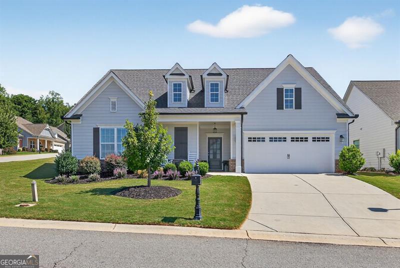 Welcome to this stunning former model home in the highly sought-after Traditions of Braselton community! Built just 2 years ago and in like-new condition, this 4-bedroom, 3-bathroom home sits proudly on a corner lot with a beautifully landscaped, fenced yard. Inside, you'll find a spacious open-concept layout with a large primary suite on the main level, complete with a luxurious en-suite. The chef's kitchen is a dream with a huge island, white cabinetry, and granite countertops, perfect for both entertaining and everyday living. Upstairs offers a versatile bonus room-ideal for a playroom, media room, or home office. Step outside to your private retreat featuring a relaxing hot tub and plenty of space to enjoy the outdoors. Living in Traditions of Braselton means you'll have access to an array of exclusive amenities, including a private golf club, resort-style pool, tennis and pickle ball courts, a fitness center, walking trails, and a community restaurant-all just steps from your door. This home truly has it all-luxury, comfort, and a vibrant lifestyle!