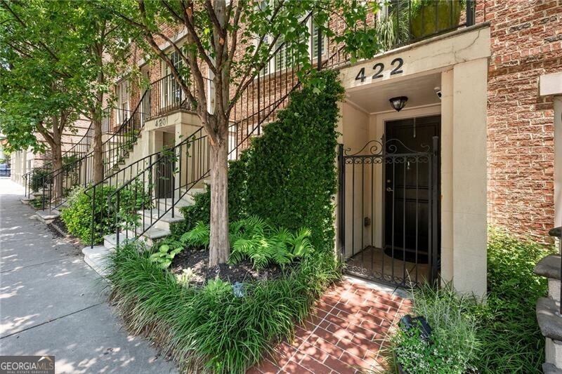 Front-row access to the Beltline, inspired design by Historical Concepts, and a standout location in Glenwood Park make this row home a rare find in the city. The classic brick exterior and curved stone staircase create a memorable entrance, leading into a beautifully updated interior with hardwood floors and natural light in every room. The main level features an open-concept layout with a spacious living area, a dedicated dining space, and a remodeled chef's kitchen with quartz countertops, an extended island, Rejuvenation hardware, and high-end appliances, including a professional grade gas stove. It's ideal for everyday living or entertaining in style. Upstairs, the primary suite includes two custom closets and an updated en-suite bath featuring honed Calacatta marble, dual vanities, and a large walk-in shower. A secondary bedroom with its own updated full bath offers comfort and privacy. The rooftop terrace brings a private outdoor element to the home, with a refinished cedar pergola and generous space for lounging, dining, or enjoying fresh air above the treetops. On the first level, a third bedroom with a renovated full bath and separate street-level entrance creates a flexible space for guests, a home office, or rental opportunity. The two-car tandem garage and ample guest parking offer convenience rarely found in intown living. Glenwood Park is a true urban village with tree-lined streets, private parks, dog park, and beloved local businesses. Optional gym and pool memberships add to the lifestyle, and with the Beltline, Madison Yards, grocery stores, and dining just a quick walk away, this home offers the perfect balance of neighborhood charm and city energy.