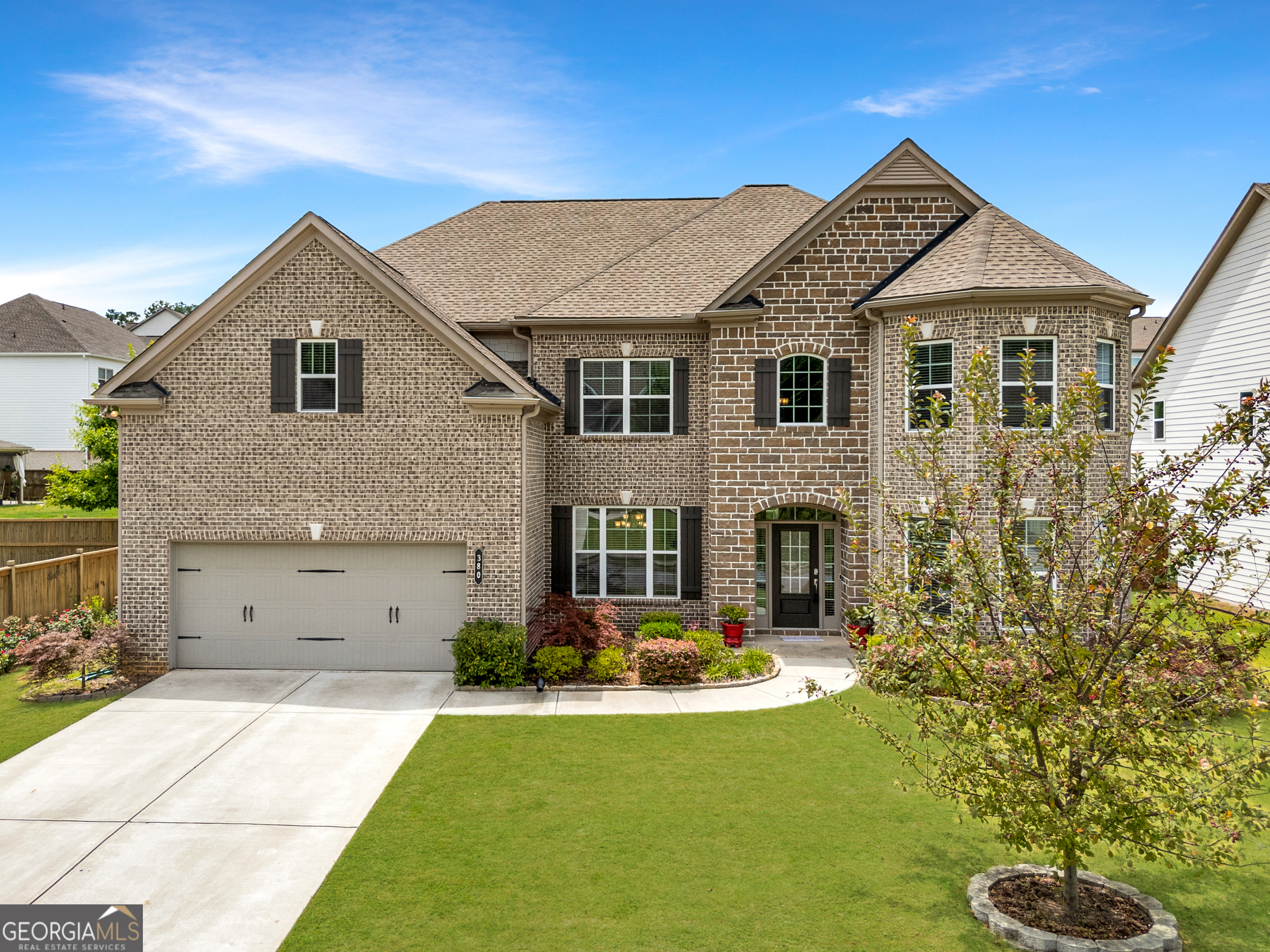 Highly sought after West Cobb neighborhood at Parkside Meadows community. Step into this beautifully designed traditional brick-front home with an elegant natural stone accent entry, offering both curb appeal and timeless charm. Boasting an open floor plan with 10-foot high ceilings on the main level, this home provides a perfect blend of spaciousness and style. The oversized master suite is a true retreat, complete with a large walk-in closet and a spa-like ensuite featuring ahis and her vanity, large separate soaking tub, and standing shower. Additional bedrooms are generously sized, while the media room offers the perfect space for entertainment or relaxation. The chef's kitchen is a dream, featuring solid surface counters, a large island, a pantry, and beautifully stained cabinets. High-end appliances include a gas cooktop, electric oven, microwave, and dishwasher, making meal prep effortless. The separate dining room is ideal for hosting gatherings, while the luxury vinyl flooring adds both elegance and durability throughout. Spacious fenced backyard with home grown fruit trees, large space that is great for your family pets to roam around and enjoy. Enjoy your weekend BBQ under the large covered patio porch.