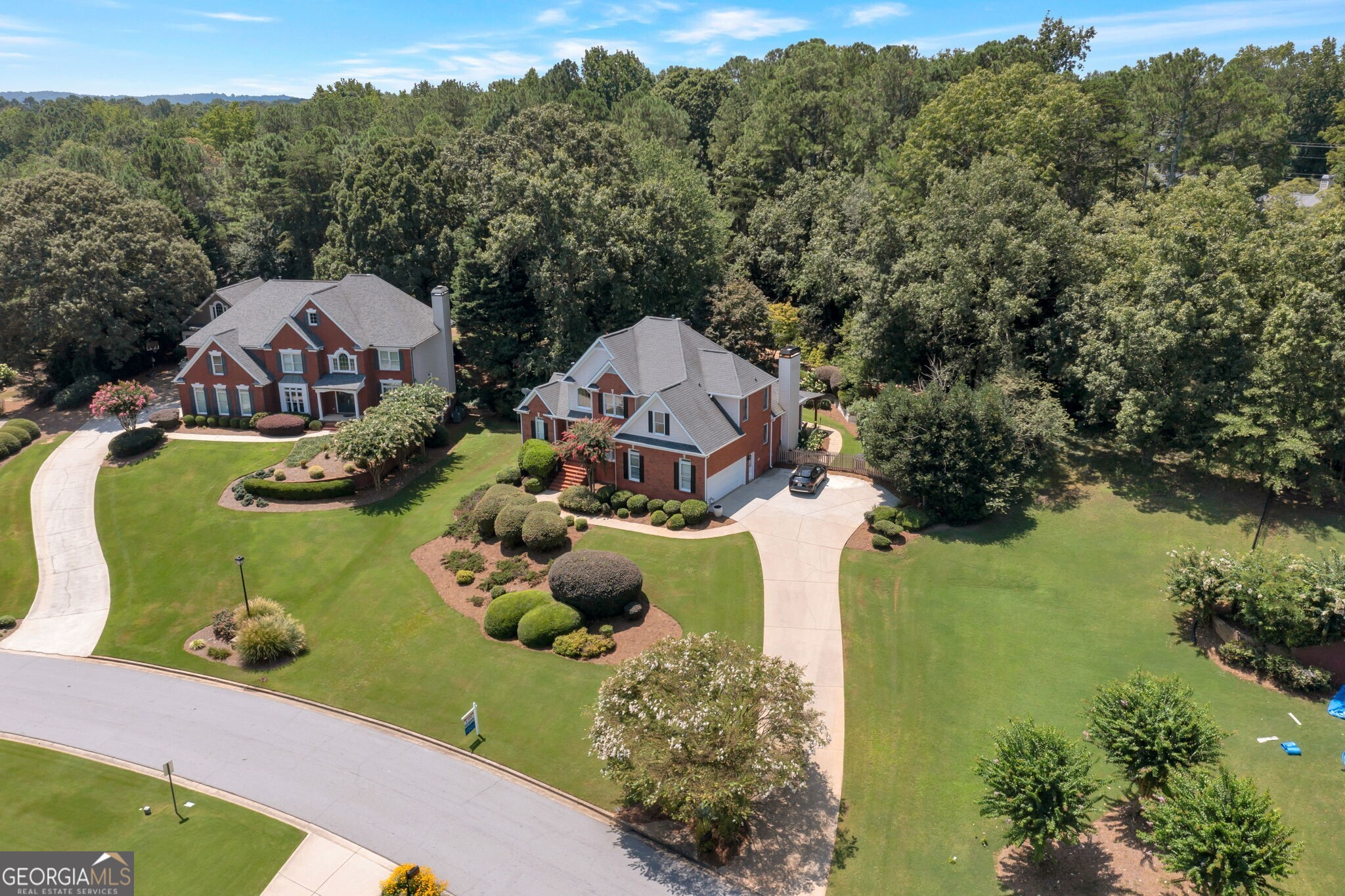 Fantastic opportunity to own a 4-sides brick, 5-bedroom, 4.5-bath home with a full basement in a sought-after 55-acre lake community! The impressive 2-story foyer with hardwood floors opens to a formal dining room, also with hardwoods. The soaring 2-story great room features a cozy fireplace and custom windows overlooking the private backyard. The vaulted gourmet kitchen is a chef's delight with granite countertops, high-end stainless steel appliances, a breakfast bar, and a sunny breakfast nook. The adjoining vaulted keeping room offers a second fireplace. The main-level primary suite boasts a tray ceiling, a wall of windows, and a large walk-in closet with built-ins. The spa-like primary bath includes dual vanities, a tile shower, and a jetted tub. Upstairs you'll find three spacious bedrooms and two additional full baths. The finished terrace level offers a 5th bedroom and full bath, a large rec room with a wet bar, and ample unfinished storage space. Step outside to your own backyard paradise featuring a covered patio, expanded firepit area, a tranquil waterfall and koi pond, and professionally landscaped gardens. Located in a vibrant lake community with swimming pools, tennis courts, a party pavilion, playground, and community dock. This home is a true must-see!