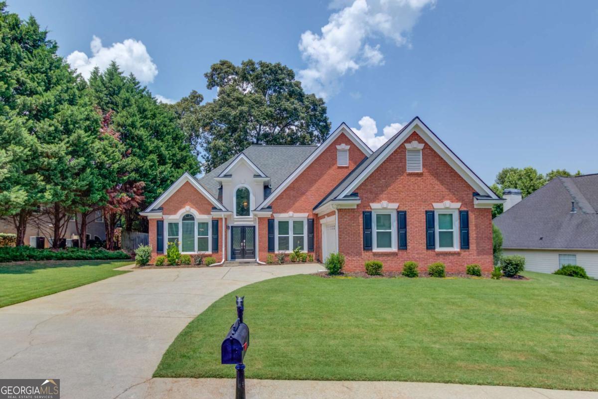 Ranch home in the North Gwinnett school district in Sugar Hill. Step into a welcoming formal living and dining area just off the foyer. The vaulted great room features a cozy gas fireplace and offers plenty of space to accommodate oversized furniture comfortably. The kitchen boasts granite countertops, a stylish tile backsplash, and stainless steel appliances. The oversized primary suite impresses with a double tray ceiling and abundant natural light. The remodeled ensuite bath is truly spa-worthy, featuring an extended tile shower with frameless glass, granite-topped vanities, updated lighting and plumbing fixtures, and a freestanding clawfoot tub to complete the luxurious design. Enjoy a spacious laundry room with updated cabinets and countertops for easy folding. The entire home has been freshly painted and features updated lighting throughout. The fenced backyard offers a level lawn, refreshed landscaping, and a large concrete patio ideal for outdoor living. Located in a swim & tennis community with quick access to GA-400, I-85, the Mall of Georgia, downtown Sugar Hill, and Suwanee.