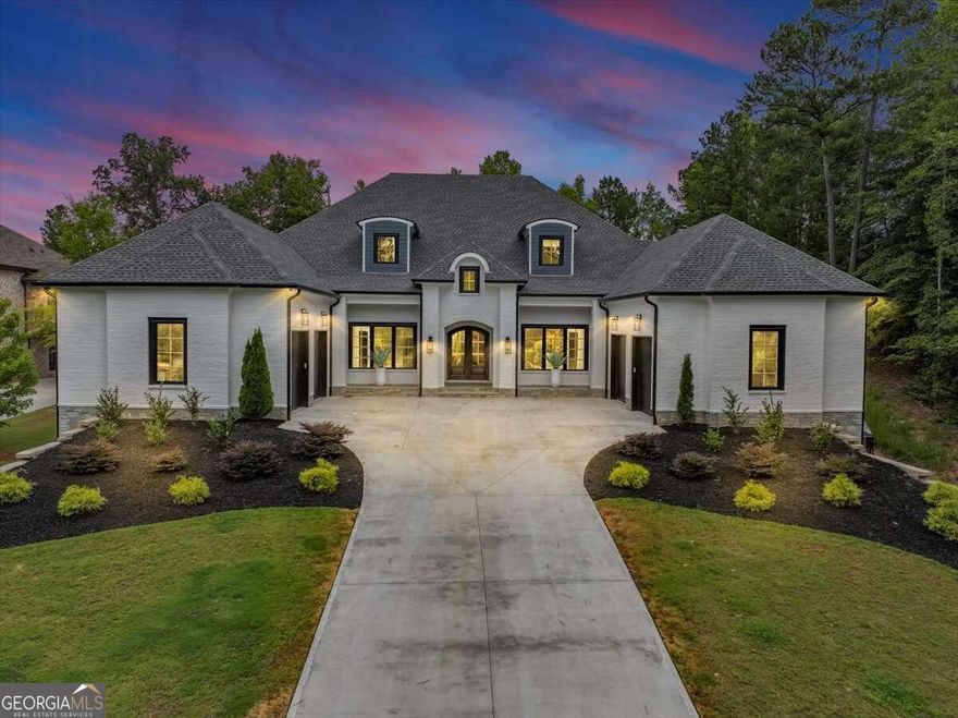 Welcome to 308 Traditions Court, an exquisite custom-built residence nestled in the prestigious gated community of Echelon, Alpharetta. This modern marvel, constructed in 2022, boasts an expansive 11,584 square feet of living space on a generous 1.59-acre lot, offering unparalleled luxury and privacy.  Upon entering, you'll be captivated by the grandeur of the main floor, featuring soaring 12-foot ceilings, an open floor plan, and gleaming hardwood floors throughout. The heart of the home is the chef's kitchen, adorned with quartz countertops, a grand island, and top-of-the-line appliances, perfect for culinary enthusiasts and entertaining.The home offers a remarkable layout with seven spacious bedrooms and six-and-a-half elegantly designed bathrooms. The primary suite is a true sanctuary, occupying a separate wing for ultimate privacy. It includes a lavish sitting room, a stunning marble bathroom with a separate tub and shower, and a custom walk-in closet complete with a washer and dryer hookup, along with a separate washer and dryer for added convenience. This residence is an entertainer's dream, featuring multiple living rooms on each level, a state-of-the-art home theater, a sophisticated wine cellar, and a unique waterfall wall. The fully finished basement includes a poker room, a podcast room, a gym, a luxurious spa area, and additional living space, ensuring every lifestyle need is met. The outdoor spaces are equally impressive, with a beautiful covered patio complete with a fireplace and plenty of room to build a custom pool on the expansive lot. The property also includes a four-car garage and a long driveway, providing abundant parking for guests. Offering instant equity and the epitome of modern elegance, 308 Traditions Court is where every detail has been meticulously crafted for luxurious living.