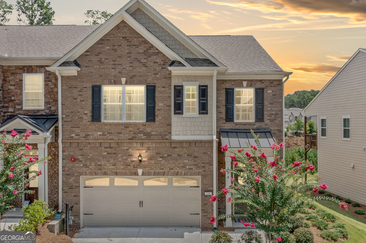 Modern design, natural light, and all the right upgrades, this 2023 build delivers the feel of new construction without the wait. From the moment you walk in, the open layout feels effortless. The kitchen features quartz counters, herringbone tile backsplash, stainless steel appliances, and a four-seat island that's made for everything from casual breakfasts to evening wine with friends. Wide-plank floors run throughout the main level, connecting the living and dining spaces with clean lines and warm tones. The living area is styled with oversized windows and a painted brick fireplace flanked by custom shiplap accents, bringing both character and comfort. French doors lead out to a fenced backyard with wooded views and no direct neighbors behind you. Upstairs, the primary suite goes beyond the basics with a private sitting area or office nook, a walk-in closet, and a bathroom that feels like a retreat. Think dual vanities, marble-look tile, a soaking tub, and a glass-enclosed shower. Tucked in a well-maintained community just minutes from Highway 92 and I-575, this home has a smart design with everyday functionality. Stylish, practical, and truly move-in ready.