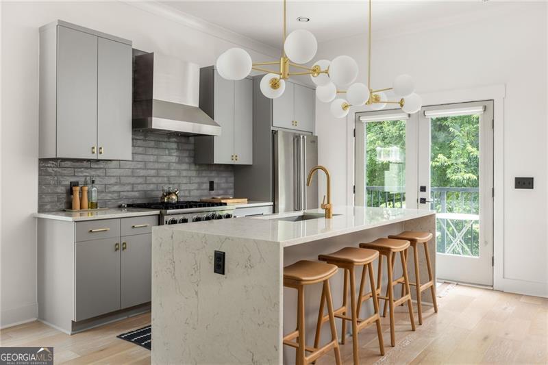 Wake up in the heart of Lake Claire where local restaurants, coffee shops, Candler Park, and Pullman Yards are just steps from your door. Come home to a space that blends modern luxury with the easy charm of intown living. This end unit townhome at Oxford Row delivers soaring ten foot ceilings, hardwood floors, and light streaming through oversized windows from the moment you step inside. The chef's kitchen is the true heart of the home with a large island offering storage and seating, Viking appliances, quartz countertops, and room for a cozy breakfast nook. Flow easily from the kitchen to the dining area and light-filled living room, then step out to the balcony for morning coffee or an al fresco dinner with a peaceful tree-filled view. Upstairs, the primary suite is your private retreat with a spacious closet and custom built-in system. The ensuite bathroom feels like a spa with high-end tile, dual vanities, and a calming design made for unwinding. This level also includes a secondary bedroom with en-suite bath and a well-sized laundry room for everyday convenience. The rooftop level will quickly become your favorite hangout space with its expansive terrace offering 360 degree views of the surrounding neighborhoods. Whether you are sharing dinner with friends under the stars or soaking in the southern sun, it is the perfect finishing touch. On the entry level, you will find a spacious third bedroom with its own ensuite bathroom, perfect for overnight guests or a dedicated office space. Built-in shelves near the garage entry keep coats, shoes, and daily essentials neatly tucked away, and the two car garage provides secure parking and extra storage for peace of mind. Move-in ready, loaded with upgrades, and walkable to the best dining, shopping, and green spaces in Atlanta, this Lake Claire home checks every box.