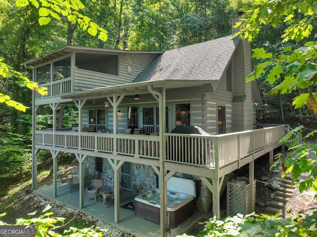 Quintessential Mountain Living - This mountaintop cabin has it all: location, view, privacy & appeal! This 3BR, 3BA chink dovetail real log home offers a spacious open floor plan great for entertaining yet offering privacy. From the moment you step inside, you'll notice detailed cabin finishes including rough sewn beams throughout, pine wood flooring, soaring cathedral ceilings, lot of windows & fixed glass in great rm & rustic style staircase w/ mountain laurel "twig" stair railings & pickets. Large covered porch spans front of home connecting to open side wrap around deck overlooking this gorgeous layered year round view offering the mountains w/ Lake Blue Ridge Mountain view. Finished terrace level features Rec Rm/Den + BR/BA opening onto terrace level patio featuring a hot tub & outdoor seating + pathway to outdoor living fire pit area offering the perfect relaxation needed for the close of your day. Primary suite upstairs features oversized BR & BA w/ small loft perfect for a home office, reading nook, additional sleeping or whatever flex purpose you may need + private "treehouse" balcony". w/ private "tree house" balcony porch. Located in the prime Aska Adventure Area near Lake Blue Ridge, the Toccoa River & approx. 10 minutes to downtown Blue Ridge offering easy access to shopping, dining, local attractions, activities & more. This property is only one property away from being directly adjacent to USFS, great for future built in privacy. Nestled on 1.88 beautiful wooded acres w/ towering hardwoods & native flora galore offering lots of privacy. This would be an amazing short term rental (STR) investment opportunity. May be purchased turn key for a one stop shop!