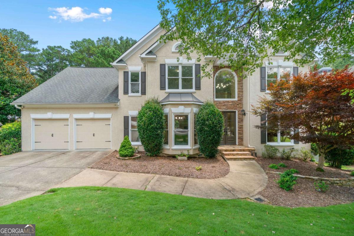 A remarkable one-of-a-kind home situated in the sought-after Eagle Watch community. This breathtaking residence is positioned on a manicured, level, fenced lot that will enchant you from the moment you arrive. Unwind on your deck while taking in views of your putting green and private sport court, which easily converts into a pickleball court. In the distance, a path from the backyard meanders through Corp property leading to the serene waters' edge of Lake Allatoona. Enjoy the pleasures of Lake Allatoona right in your own backyard! This splendid home features 5 bedrooms, 4.5 full baths, presenting a perfect blend of comfortable interiors and resort-style outdoor living. Inside, you will discover soaring ceilings, a dedicated office space, hardwoods, open concept floorplan, and an atmosphere of timeless sophistication. The living room showcases large windows that frame the stunning property alongside a stone fireplace plus enjoy a screened porch off the family room. While the formal dining room elevates the ambiance, making it perfect for both cozy gatherings and larger celebrations. The kitchen flows into the family room, complete with a walk-in pantry and a conveniently located laundry room with a large deck off breakfast area. The primary suite is generously proportioned w/ an en-suite that has been tastefully upgraded. The three additional bedrooms upstairs are spacious, with one offering an updated en-suite bathroom. The finished basement includes a bedroom, a full bath, a family room, wet bar, and a req. area. The outdoor living space off the basement is ideal for grilling, entertaining guests and is ready for a hot tub. Eagle Watch is more than just a neighborhood; it represents a lifestyle. This is a rare chance to own property in a lively, amenity rich community, where neighborhood deer wander freely, with top-rated schools. Neighborhood amenities: 2-pools, golf, 2-parks, basketball court, tennis, pickleball, fitness center, volleyball, restaurant & sidewalks. You don't want to miss this one!