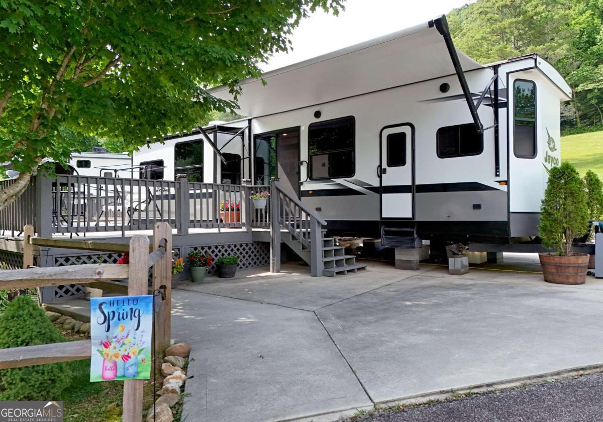Don't miss this incredible opportunity to own a STUNNING 2022 40-foot Jayco RV on a GORGEOUS CREEK FRONT LOT with AMAZING YEAR ROUND MOUNTAIN VIEWS in the highly sought-after Sunset Valley RV Park-a beautifully landscaped, year-round community! This well-maintained one-bedroom, one-bath RV features an open living room, kitchen with SS appliances, pantry, three slide-outs with awnings, Four Seasons insulation, and sits on a level lot with easy, level access right down to the creek. Enjoy the comfort of two concrete driveways, a fully finished 10X12 outbuilding with washer/dryer hookups-ideal for extra storage, a home office, or the perfect man cave. The lot also features fencing and mature trees for shade and is just a short walk to the community clubhouse. With thoughtful upgrades throughout and peaceful surroundings, this is mountain RV living at its finest! The Annual Fee covers the Septic, Water, Trash, Mowing, Road Maintenance, Clubhouse w/baths and laundry. This is a Year Round Park! You must see this property!