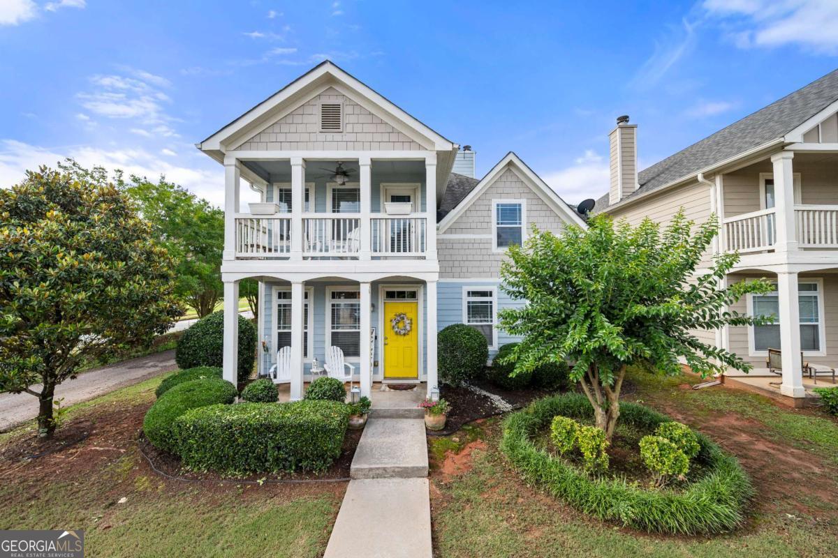 Welcome to this stunning former model home, perfectly positioned on a spacious corner lot and exuding timeless Cape Cod charm. A covered rocking chair front porch invites you inside, where refined details and custom finishes set the tone. Step into a beautifully appointed formal living and dining room featuring elegant crown molding and a decorative wood accent wall. The gourmet kitchen is a chef's dream-complete with granite countertops, diamond-pattern tile backsplash, tall chestnut cabinetry, and stainless steel appliances, including a refrigerator, microwave, dishwasher, stove, and washer/dryer-all thoughtfully included. Recessed lighting and archways lead into the expansive family room, which boasts a cozy fireplace and oak-look LVP flooring throughout the main level. Wrought iron spindles guide you upstairs to an exceptional primary suite with trey ceilings, a private sitting room which leads out to its own balcony, and a luxurious en-suite bath featuring dual side fireplace, dual vanities, a jetted Jacuzzi tub, separate shower, and a custom walk-in closet system. Three oversized secondary bedrooms feature soaring double trey ceilings and share a well-appointed hall bath. Rear parking is available, and while there is no garage, the versatile flex space offers additional functionality to suit your needs which is ideal for an office, gym, playroom, or creative space. Also featuring a powder room on the main and ceiling fans throughout. This former model home blends comfort, style, and functionality in one exceptional package-just minutes from schools, shopping, and commuter routes.
