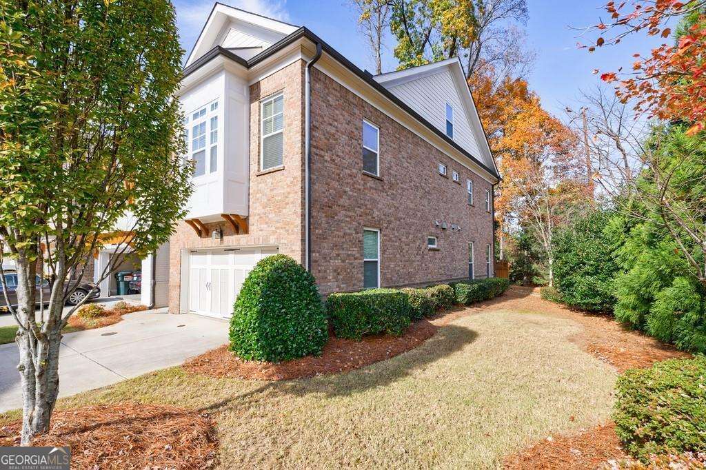 Luxurious modern END UNIT townhome in coveted Alpharetta/Johns Creek location! Gated community, excellent schools, great floor plan with in-law/teen suite, fantastic location! This home has barely been lived in (the oven has never been used). Open floor plan, beautiful hardwood floors, kitchen features quartz countertops, a large island and lots of cabinets. Three levels of living space. The fireside family room is flanked by built-in bookcases and opens to a beautiful fenced patio with nature surrounding it. The primary suite upstairs is oversized, and features a soaking tub, large shower and large closet. Two additional bedrooms and a full bath share the second level. The third tloor features a huge bonus room and bath, which is perfect for a teeen/guest suite, media room, flex space. So much potential! Terrific location - walk to shopping and dining. 10 minutes to Avalon, 15 minutes to Downtown Alpharetta! Welcome home to your new carefree and convenient lifestyle.