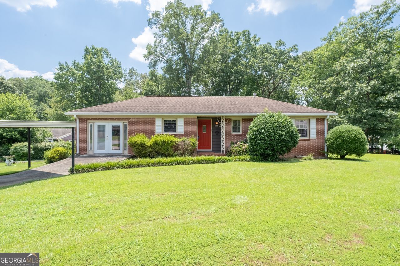 Wonderful 4 sides brick ranch on a park like corner lot in desirable Smyrna! This classic ranch features 3 Bedrooms 2 Full baths plus a large Den with warm masonry fireplace added onto home by current owner. The Chefs' kitchen features stained wood cabinets, vinyl flooring, good counter space and granite tops. Formal Dining Room off kitchen. Primary bedroom also expanded to include a second closet and larger full bathroom. The second Den or Bonus Room is located off the Kitchen and offers extra square footage. It was the original carport. Generous Laundry room is located off the second Den. French Doors off larger den leads to a very peaceful screened porch. Yard is a gardeners delight with a large level fenced sodded yard and an outbuilding that remains for additional storage. Other Owner improvements include covered parking, newer windows and a brand-new June 2025 Heating and Air system using R-32 along with a new CO 2 detector. Under carpet in much of the home are hardwood floors. Home is vacant but easy appt with agent.