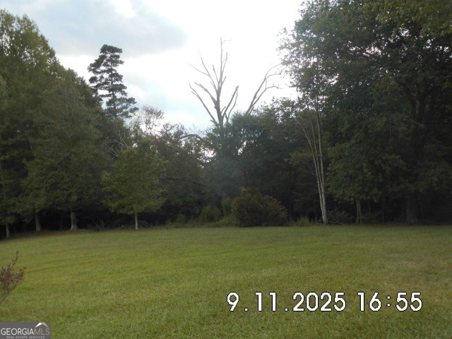 This beautiful wooded 8.5+/- acreage would make a beautiful homesite or to be developed into a small subdivision with the possibility of have 8 or more homesites. With over 572' of paved county road frontage gives this property lots of possibilities. The only restrictions are county restrictions only. This property DOES NOT include my office (brick house)