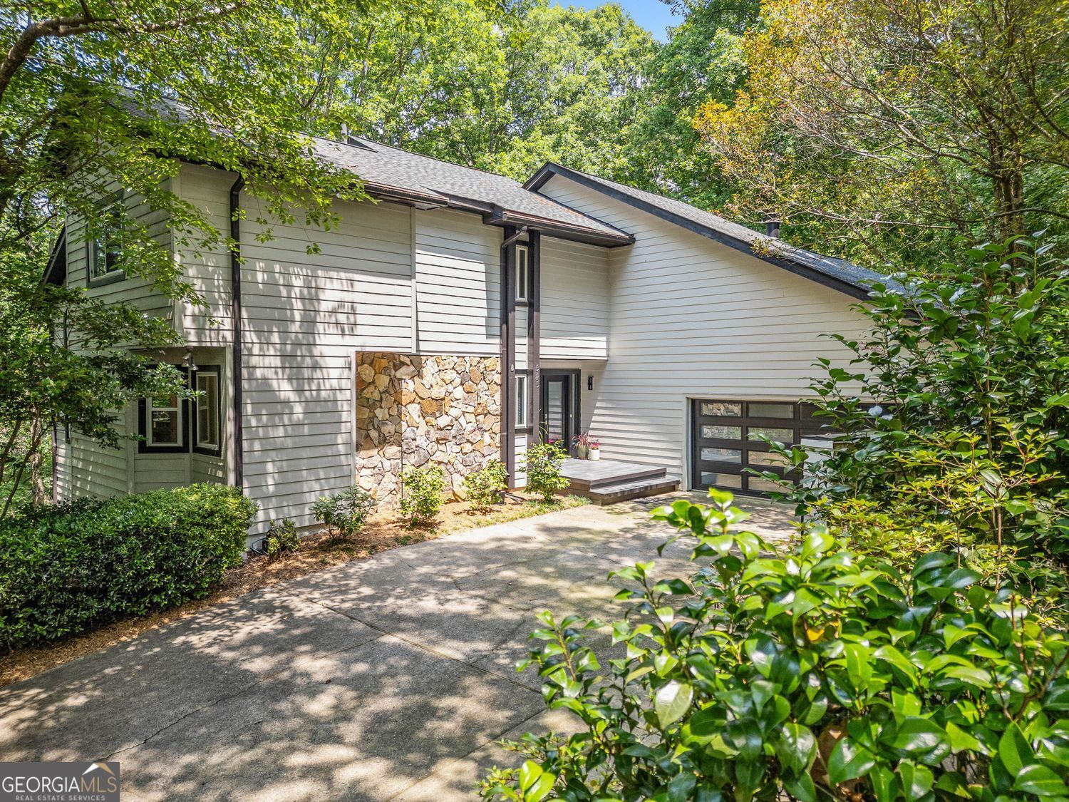 Mountain-Inspired Retreat in the Heart of Johns Creek. Tucked away on a quiet cul-de-sac in the highly sought-after Rivermont community, this bright and spacious 5-bedroom, 3.5-bath home offers the perfect balance of mountain retreat charm and suburban convenience. Step inside to a welcoming two-story foyer that opens to a grand family room featuring vaulted ceilings, a cozy fireplace, and a dramatic wall of windows that flood the space with natural light. The renovated owner's suite on the main level boasts hardwood floors, a luxurious en-suite bath, and a private deck overlooking the peaceful, wooded backyard. The updated kitchen is a chef's delight with granite countertops, newer cabinetry, stainless steel appliances, coffered ceilings, and a breakfast bar. The adjacent keeping room with fireplace flows seamlessly to the expansive deck, perfect for outdoor entertaining. Upstairs, you'll find spacious secondary bedrooms and well-appointed baths, while the finished terrace level offers a billiard/game room, flex space ideal for an office, gym, or additional bedroom, plus unfinished storage/workshop space ready to meet your needs. Enjoy access to Rivermont's private park on the Chattahoochee River, along with proximity to top-rated schools, local dining, shopping, and all the natural beauty of North Fulton County.