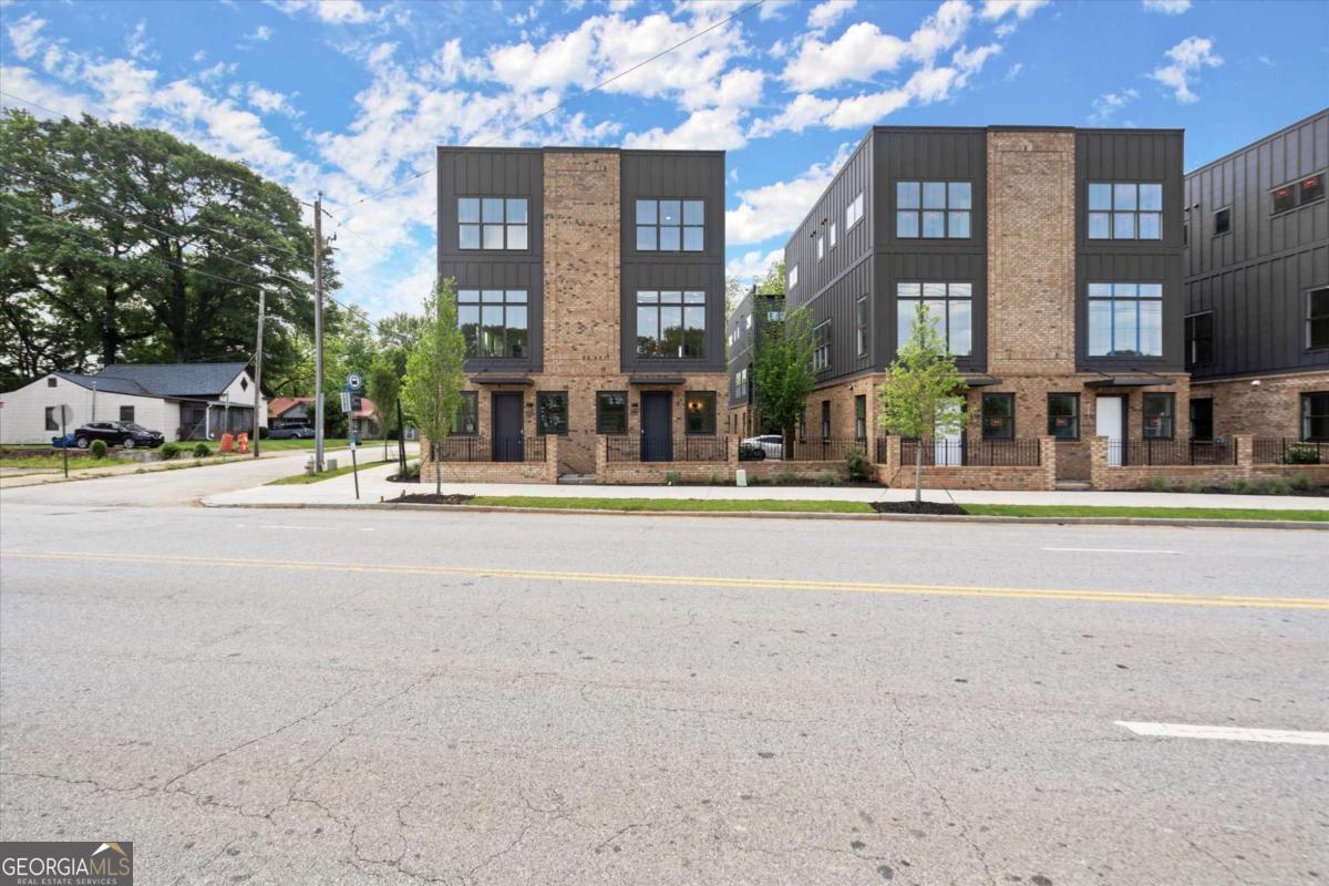 Knights Walk at Howell Station, where every unit is an end unit. These brick and batten board clad, fee simple CityHomes are the latest offering from Middle Housing Company. Abundant natural light is provided by windows on three sides of every unit. Real usable outdoor space is found on the large, covered deck adjacent to the kitchen, while front units facing West Marietta St include a front patio as well. The lower level includes a half bath and a single-car garage with extra storage. The main level includes a great room with living and dining areas, a well-appointed kitchen, and a covered rear deck. The light-filled upper level has a primary suite with ensuite bathroom with double vanity, large floor-to-ceiling tile shower, and a separate water closet. The secondary bedroom, bathroom, and laundry closet complete the upper level. Floors are durable luxury vinyl throughout the unit, and all countertops are quartz. Two different kitchen layouts are available. Knight Walk at Howell Station includes a dog walk and a community common area. This walkable location is only blocks away from Knight Park, the Beltline entrance adjacent to Westside Paper and King Plow.