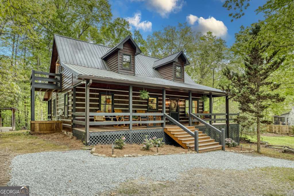 This is a premier short-term rental investment or private mountain escape! Nestled on two rare, flat acres in the heart of North Georgia, this fully furnished three-bedroom, two-bathroom cabin is designed for both guest appeal and investor success. Ideally located just minutes from Lake Blue Ridge and downtown Blue Ridge, this property offers the perfect balance of seclusion and convenience. As you drive up, there is an easy-in, easy-out circular driveway. Stepping inside, you'll find floor-to-ceiling windows that flood the open-concept living space with natural light. A wood-burning fireplace serves as the focal point, creating a warm and inviting atmosphere for guests to gather. The modern lighting, tasteful furnishings, and well-appointed kitchen ensure a comfortable and seamless guest experience. Investors, the thoughtfully designed layout comfortably accommodates up to eight guests, with two bedrooms on the main level with full beds. Upstairs, the private loft suite with queen bed features its own bathroom, workspace, and additional seating area, providing a retreat-like experience. There is a large wraparound deck with a hot tub, and the fire pit with Adirondack chairs invites guests to relax under the stars. The expansive, flat acreage provides space for families to enjoy outdoor activities worry-free, a rare find in this mountainous region. There is even enough space to create your own pickleball court! Outdoor amenities are a major draw for visitors. This home is within walking distance of the community pond. Located on paved roads with easy access to hiking trails, wineries, shopping, and dining, this property is primed for a successful rental investment. Whether you're looking to capitalize on the thriving short-term rental market or seeking your own turnkey vacation retreat, this Bougie Cabin is ready to welcome you. (Pickleball Court Is Virtually Staged.)