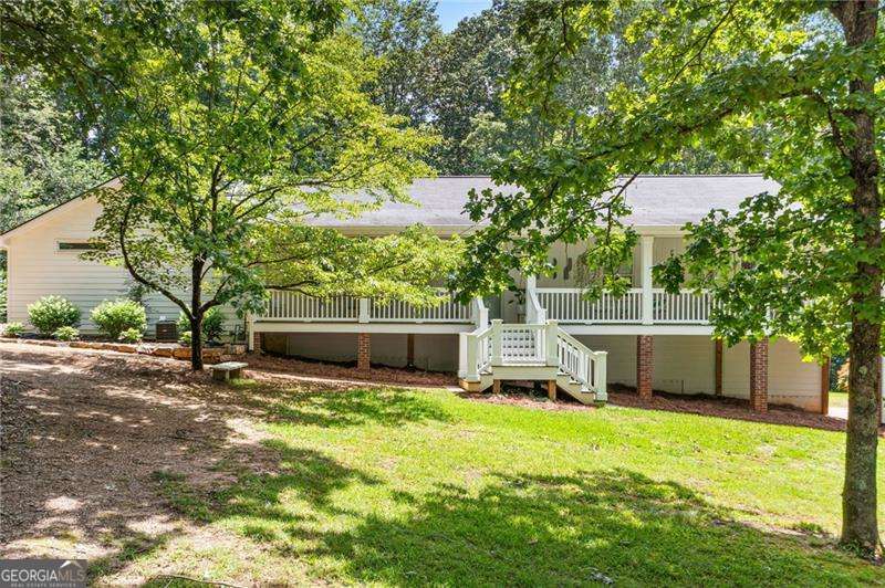 WELCOME TO YOUR OWN PRIVATE SANCTUARY - a one-of-a-kind masterpiece that perfectly blends luxury, charm, and comfort on over 2 acres of peaceful, landscaped beauty. From the moment you arrive, you'll be captivated by the expansive front porch that stretches across nearly the entire front of the home - an outdoor living space made for morning coffee, evening conversations, and soaking in nature's beauty. Step inside to a fully renovated main level that exudes modern elegance with custom trim throughout and an open-concept layout designed for both entertaining and everyday living. The brand-new kitchen is a true showstopper, featuring stunning white cabinetry, quartz countertops, stainless steel appliances, a large center island with tons of storage, and a spacious dining area - all flowing seamlessly into the oversized family room. A light-filled sunroom overlooks a serene backyard, where deer are frequent visitors, adding to the home's tranquil vibe. The crown jewel of the home is the **650 sq ft primary suite addition**, a true retreat with vaulted and beamed ceilings, double doors to the back deck, a spacious walk-in closet with laundry, and a spa-like bath complete with soaking tub, dual vanities, and an enormous walk-in shower. This home offers **a SECOND luxurious owner's suites** which has a beautifully remodeled en-suite and walk-in closet. Two additional generously-sized bedrooms on the main level - four bedrooms total. Downstairs, the finished basement provides incredible versatility with space for an office, media room, or rec room, a full bath, second laundry hook-up, and ample storage. Step out back to enjoy the deck overlooking the sprawling, private backyard - complete with a fire pit area, new rock wall, and gorgeous landscaping. Whether you want to garden, let the kids roam, or even bring horses, there's room for it all. Every inch of this home has been thoughtfully crafted and meticulously maintained - a rare opportunity to own a truly special property that offers space, privacy, and modern luxury in one perfect package. And to top it off it is located in a fantastic location with easy access to shopping and dining in all directions, plus a fantastic school district!