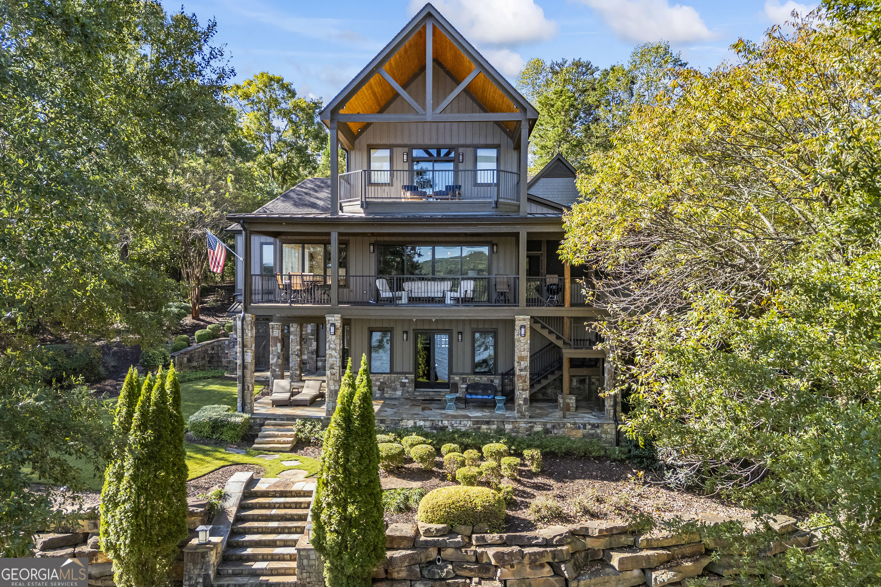 Luxury Lakefront Living on Lake Hartwell. This stunning home boasts upscale, casual elegance with breathtaking lake views and a close Corp Line. The gorgeous architecture features mahogany floors and steps, creating a sophisticated yet warm atmosphere. Each of the five bedrooms comes with its own ensuite bathroom, beautifully designed with tile and stone for added charm. Layered decks and outdoor living areas ensure every level enjoys the great outdoors, including the terrace-level bedroom with its own private covered porch and stone fireplace. The screened porch seamlessly extends the family room, making it perfect for year-round entertaining. The dining room, flooded with natural light, comfortably seats 12, while the living and dining areas share a two-sided fireplace for added ambiance. The master suite is a luxurious retreat with sweeping views of Lake Hartwell, a private deck, a fireplace, and a spa-like bathroom. The custom closet even includes a "secret door" to the back staircase! Outside, the Ironwood single-slip dock with a boat lift and hipped roof is ready for you to start enjoying lake life immediately. For added convenience, three closets are perfectly aligned for a future elevator, currently serving as extra storage and a dry bar. Recently, the owners have updated most appliances, replaced 3 of the 4 HVAC units, and repainted exterior. Located in the prestigious Currahee Club, a private golf, mountain, and lake community, this home offers access to an 18-hole Jim Fazio golf course, hiking trails, a clubhouse, and more. This is your opportunity to enjoy luxury lakefront living at its finest!
