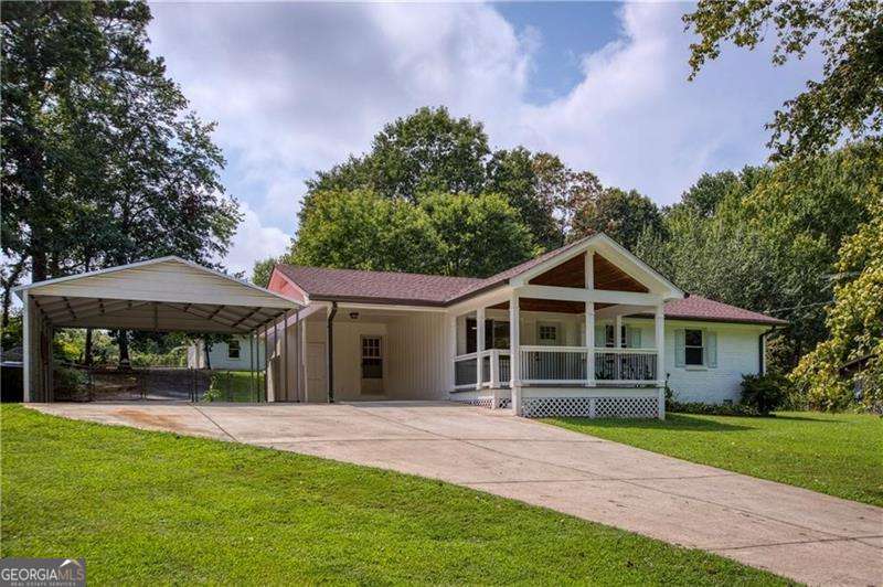 Charming Renovated White Farmhouse in West Forsyth - No HOA! Brand New HVAC! Step into this beautifully renovated white painted brick ranch nestled in the sought-after West Forsyth school district. Ranch home with walk-out backyard. With classic farmhouse charm and modern updates throughout, this home is move-in ready and packed with upgrades. The cedar vaulted front porch welcomes you inside to hardwood floors & fresh paint that flow through every room. Enjoy a brand-new kitchen featuring extended shaker cabinetry, stainless steel appliances, and sleek quartz countertops. The fully renovated bathroom showcases custom tilework and a stylish wood vanity. All three bedrooms are bright and inviting, complemented by new farmhouse trim, upgraded lighting, and new doors throughout. Outside, relax on the screened back porch or entertain in your private, fenced backyard. A large carport, detached garage/storage building with a private drive is the perfect workshop for hobbies, parking, or storage. The crawl space has been professionally wrapped with a new vapor barrier. Perfect blend of country style and modern comfort. Great investment property, first time home or those looking to downsize to one level living!