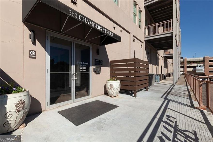 Discover the ideal blend of comfort, convenience, and classic charm in this beautifully appointed condo located in the heart of Downtown Woodstock. Perfectly situated at 360 Chambers Street, Unit 208, this home offers refined living just steps from the city's best dining, boutique shopping, and entertainment.  Step inside to find a warm and inviting interior filled with traditional details and quality craftsmanship. The kitchen serves as the heart of the home, showcasing stone countertops, crown molding, a stylish backsplash, and a spacious island with breakfast bar-perfect for cooking, entertaining, or simply enjoying your morning coffee.  The bedrooms provide peaceful retreats, each enhanced with crown molding and thoughtful layouts. The primary suite features a beautifully tiled walk-in shower and a deep soaking tub, creating a spa-like space for relaxation. The secondary bathroom offers a tub/shower combo and excellent lighting, ideal for guests or family.  The living room exudes warmth and comfort, filled with natural light and designed for easy living. Step out onto your private balcony and enjoy a serene wooded view, where you can start your mornings with peaceful sunrises or unwind in the evening surrounded by nature's calm - all within walking distance of the vibrant downtown scene.  Lovingly maintained and move-in ready, this home embodies a timeless sense of style and effortless livability - making it one of the most desirable condos in Downtown Woodstock.