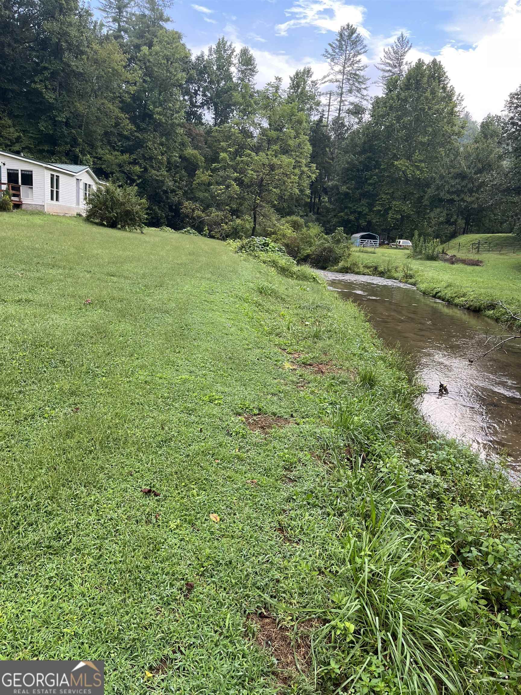 This charming 2-bedroom, 2-bath country home situated on 2.15 acres along a 600+ ft trout stream on Warwoman Rd offers a peaceful, self-sustaining lifestyle, ideal for fishing enthusiasts and nature lovers alike. The property features recent updates to the kitchen and baths, creating a cozy retreat with versatile space for relaxation or hobbies, while a garden spot to enhances its self-sufficiency. The trout stream provides excellent opportunities for fly fishing and immersing oneself in nature's tranquility, making this property a perfect haven for outdoor recreation and serene living, with a few finishing touches needed to fully realize its potential.