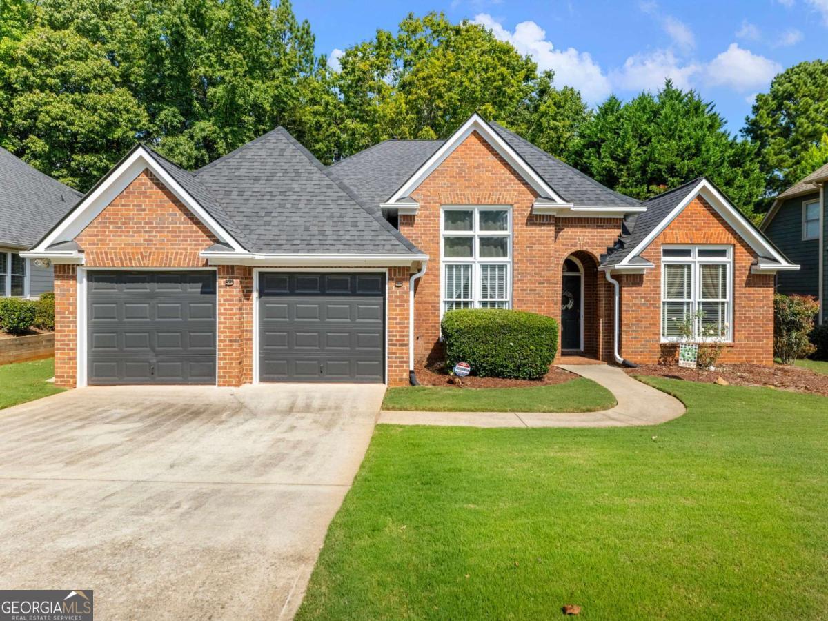 Welcome to this charming STEPLESS BRICK RANCH perfectly positioned on the 18th fairway in the highly sought-after Riverside at Apalachee Farms community. Offering resort-style amenities, this vibrant neighborhood features a driving range, golf course, clubhouse, multiple pools, one with a slide and shallow area for little swimmers, multiple tennis and pickleball courts, fitness center, playground, pavilion, walking trails, and more. Reputable schools, and plenty of parks and recreational facilities nearby. Conveniently located just minutes from shopping, dining, and year-round entertainment, this home delivers the perfect balance of relaxation and accessibility. The home boasts fresh exterior paint, LEAF GUARD GUTTER SYSTEM, two-car, separate-door garage, and a welcoming covered front entry. Step inside to a spacious foyer flanked by a vaulted formal living room (currently being used as a home office) and a large formal dining room, both with French doors for an elegant touch. At the heart of the home, you'll find a bright, open layout complete with a family room, cozy fireplace, and an additional dining area. Well-designed kitchen is equipped with refinished cabinetry, breakfast bar, island, pantry, and ample counter space. The laundry room offers added convenience with a wash sink. The SPLIT-BEDROOM FLOOR PLAN provides privacy, with the spacious primary suite on one side featuring a double vanity, jetted soaking tub, and walk-in shower. Two additional secondary bedrooms and a full bath are located on the opposite side of the home, perfect for family or guests. Enjoy outdoor living in the fully fenced backyard, complete with a patio, shade trees, and a wooded backdrop for a peaceful, private feel. With no rear neighbors and seasonal views of the golf course, it's an ideal setting for relaxation and entertaining. Additional highlights include a newer retaining wall, and a stepping stone walkway from the driveway to the backyard. This home offers great bones and an effortless layout, serving as a blank slate ready for you to update and customize to suit your lifestyle. Experience the ultimate combination of location, community, and potential in one of the area's most desirable neighborhoods.