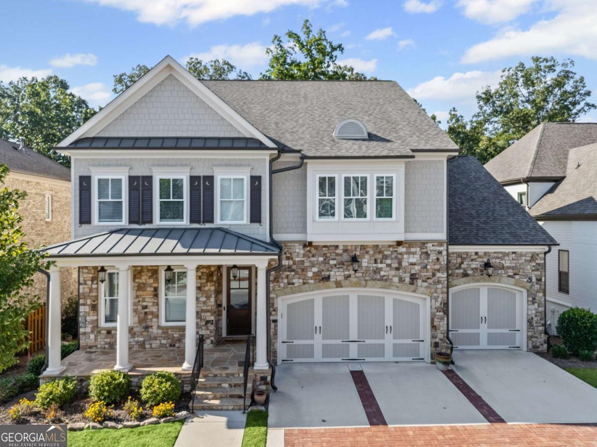 Welcome to the pinnacle of elegance and comfort in the prestigious, gated community of Bellmoore Park-where this stunning residence perfectly balances refined design, thoughtful upgrades, and family-friendly functionality. Situated on a premium, private lot backing to serene wooded greenspace, the home radiates curb appeal from the moment you arrive. A charming front porch invites you inside to a beautifully curated interior, where wide-plank hardwood floors, custom designer finishes, and sophisticated details set the tone throughout. The main level offers a versatile layout ideal for multi-generational living, complete with two spacious bedrooms-perfect for guests, teens, in-laws, or a dedicated home office. Each bathroom showcases designer tilework, upgraded cabinetry, and elegant furniture-style vanities, creating a consistent high-end aesthetic. The expansive open-concept living area makes entertaining effortless, with a formal dining room flowing into a warm and inviting family room anchored by a floor-to-ceiling brick fireplace. A wall of windows with electric blinds bathes the space in natural light, while the chef's kitchen stands as the heart of the home-featuring a large center island, quartz countertops, stainless steel appliances, double ovens, undercabinet lighting, and extensive upgraded cabinetry. Step through double doors to the extended deck, thoughtfully designed with both covered and uncovered spaces-ideal for morning coffee, evening wine, or simply enjoying the tranquil wooded backdrop. Adjacent to the kitchen, a convenient mudroom with custom built-ins, full bathroom, and additional bedroom add everyday functionality. Upstairs, a beautifully designed landing with hardwood floors and wainscoting leads to three spacious secondary bedrooms, each with walk-in closets. The Jack-and-Jill layout offers a dual-sink vanity and stylish finishes, while a cozy built-in window seat adds charm and practicality. The show-stopping owner's suite is a true retreat, featuring a tray ceiling, expansive layout, spa-like bath with his-and-her vanities, soaking tub, fully tiled shower, and an oversized walk-in closet with custom organization. The full daylight basement is ready for your personal touch-whether a home theater, gym, playroom, or in-law suite. Step outside to a beautifully manicured backyard and extended patio, perfect for entertaining or peaceful relaxation. A three-car garage and Bellmoore Park's premier amenities-including resort-style pools, tennis courts, clubhouse, fitness center, and access to top-rated schools-complete the lifestyle. And if you and your family WANT MORE? You can enjoy the highly anticipated Medley Development (soon), Johns Creek's visionary new Town Center located just minutes away. Spanning 43 acres, Medley will bring an exciting mix of upscale dining, boutique shopping, entertainment, a boutique hotel, and thoughtfully designed green spaces together in a vibrant, walkable community hub. With a central plaza set to host year-round events, live music, and festivals, along with modern townhomes, luxury residences, and lifestyle office space, Medley is designed to be the city's true gathering place. Scheduled for completion in 2026, this transformative development will offer Bellmoore Park homeowners unparalleled convenience and access to the very best of Johns Creek's future.