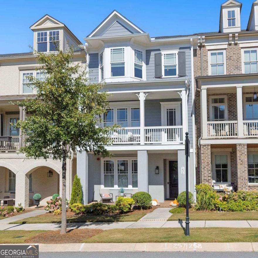 Beautifully appointed townhome located in the award-winning South on Main community in Downtown Woodstock. This stylish Andrews plan offers three finished levels of thoughtfully designed living space with exceptional attention to detail. The terrace level welcomes you with a warm foyer leading to a private guest suite featuring a full bath and charming barn door-ideal for visitors or a dedicated home office. The rear-entry two-car garage opens to a convenient drop zone with built-in storage for everyday organization.  The main living area is bright and open, centered around a spacious family room with a fireplace, built-in shelving, and access to a covered front balcony perfect for relaxing or enjoying your morning coffee. The adjoining dining area includes a built-in bar with a beverage cooler, offering a seamless flow for entertaining. A true highlight of the home is the gourmet kitchen, showcasing elegant white cabinetry, a large island with seating, and a breakfast area enhanced by custom built-ins for added style and function. Step outside to the rear deck-an inviting space for outdoor dining or evening unwinding. A cozy keeping room and powder bath complete this level. Upstairs, the serene owner's suite features two generous walk-in closets and a luxurious spa bathroom with dual vanities and an oversized walk-in shower. The secondary bedroom is equally well-appointed, featuring a Murphy bed for flexible use and a private ensuite bath. The laundry room, equipped with cabinetry and a sink, provides both convenience and practicality. An elevator can be added if desired, as the home was designed with an optional shaft (a portion is currently used as a bar area in the dining space). Living in South on Main offers a lifestyle like no other. The community features over 20 acres of green space, including parks, walking trails, and a community garden. Enjoy resort-style amenities such as a pool with splash pad and cabana, a 6,000-square-foot clubhouse with fitness center and game room, dog parks, play areas, and The SHED stage for concerts and community gatherings. Just a short stroll from the shops, restaurants, and entertainment of Downtown Woodstock-and minutes to I-575-this location offers the perfect balance of convenience and charm. Come experience the unmatched lifestyle that makes South on Main one of Metro Atlanta's most sought-after communities.