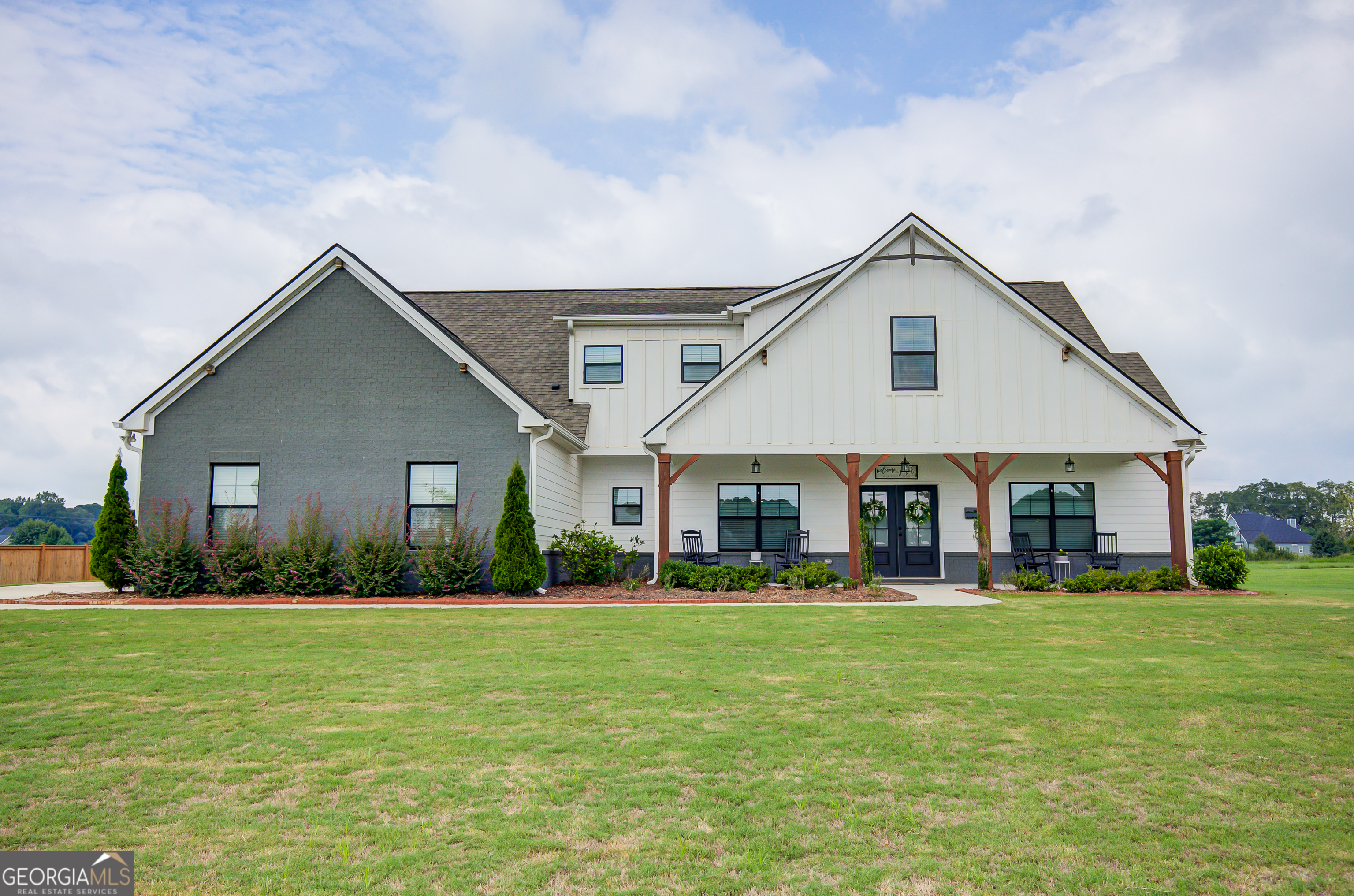 Step into style, space, and Southern charm in this nearly-new Benson F XL-an upgraded 5-bedroom retreat tucked into the heart of Grove Park, one of the area's most desirable communities. Designed with thoughtful elegance and expanded to fit your lifestyle, this home blends function with wow-factor in every room. The main-level owner's suite feels like your own personal spa-complete with a soaking tub, tiled shower, dual vanities, and a walk-in closet made to impress. Need more room? The original 4-bedroom plan was upgraded with a 5th bedroom, offering extra flexibility for guests, home office, or multi-generational living. From the moment you enter, you'll be drawn to the vaulted ceilings, wide-open layout, and rich finishes that elevate everyday living. The formal dining room features a statement coffered ceiling, while the great room centers around a stacked-stone fireplace, perfect for cozy nights in. The gourmet kitchen is as functional as it is beautiful-think granite countertops, stainless steel appliances, a show-stopping oversized island with farmhouse sink, and a walk-in pantry to keep everything tucked away. Upstairs, two spacious bedrooms, a full bath with double vanities, and a loft-style flex space offer endless possibilities-playroom, media lounge, home gym? You decide. Throughout the home, luxury vinyl plank flooring and upgraded tilework bring durability and design together seamlessly. The laundry room is both practical and refined, featuring built-in shelving and a utility sink for added convenience. Step outside and imagine entertaining on your extended patio with fireplace, hosting summer barbecues, or watching the game with friends. Love the idea of a pool? This lot was planned for it-and even includes a pre-leveled area for a future detached garage. This home delivers the perfect mix of luxury, comfort, and future-ready features-and it's move-in ready. Homes like this don't last long in Grove Park. Schedule your private showing today and experience why this one stands out from the rest.