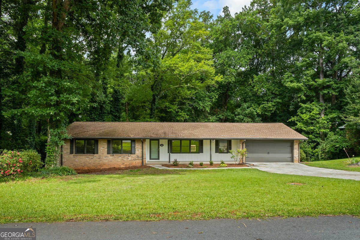 Welcome home to this newly RENOVATED property featuring 4 bedrooms, 3 full bathrooms, 2 bonus rooms, 2-car garage with a BRICK exterior and FINISHED BASEMENT on a PRIVATE 1.24 ACRE lot. You can enjoy your morning cup of coffee on the covered front porch or on the new back deck while connecting with nature. The home is great for entertaining friends and family with a flowing interior layout and the large, private backyard, and is ready to create many wonderful memories with the ones you love! With so many renovations, this home will also be stress-free and low maintenance for many years! RENOVATIONS include a NEWER roof, NEW HVAC, NEW water heater, NEW interior and exterior paint, NEW kitchen with granite and stainless appliances, NEW flooring, NEW light fixtures, NEW plumbing fixtures, UPDATED baths, NEW garage door, NEW back deck. Even the garage floor has a NEW epoxy coating that shines. Additional features include a HUGE laundry room with cabinets, 2 additional finished rooms in the BASEMENT (perfect for a media room, office, etc..) plus a large unfinished room with a single garage door. There's also another unfinished room/storm shelter! Conveniently located just minutes from the Conyers shopping & dining district & only 30 minutes from Atlanta. Contact your Realtor to schedule your private showing before it's gone!