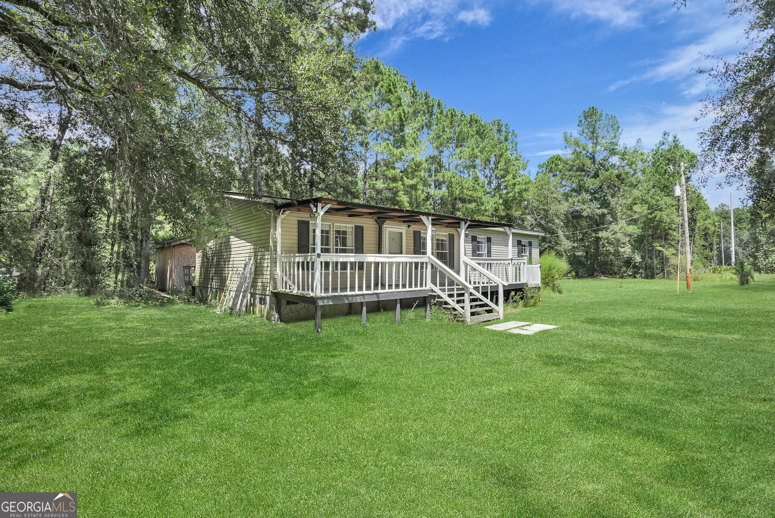 ** NEWER ROOF | PERMANENT FOUNDATION | NO FLOOD ZONE ** Discover country living with convenience at 3961 Eldora Road in Ellabell! This 4BR/2BA manufactured home is situated on nearly 4 acres and set on a permanent foundation. Enjoy the freedom of space with plenty of room for chickens, gardening, or hobby farming, plus a barn and carport already in place. Relax on the spacious front porch and take comfort knowing the roof is less than 2 years old. Additional highlights include no flood zone, a large lot with endless possibilities, and quick access to the Hyundai Mega Site, I-16, Statesboro, Savannah, Pooler, and Pembroke. The perfect blend of peaceful living and central location!