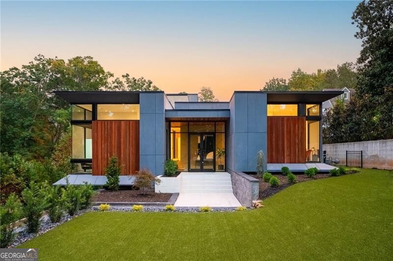Nestled in the heart of Buckhead on a sprawling 1.5 +/- acre lot, this exquisite modern masterpiece, meticulously crafted by renowned architect Scott West, awaits your discovery. The dramatic two-story living room adorned with a breathtaking PE wood ceiling, fireplace, wine tower, and a striking marble accent wall sets the tone of casual luxury found throughout. Accordion doors stretch along the entire back side of the home leading to a covered entertaining area featuring an outdoor fireplace, infinity edge pool with a spa and PebbleTec coating, all overlooking the private flat yard with sunset views. The kitchen boasts custom German cabinetry, Gaggenau appliances, Subzero refrigerator, a built-in Meile coffee maker, walk-in pantry and an expansive quartz island. The main level primary suite features a stunning marble accent wall that guides you to a spa-like bathroom with an app-controlled sauna, double vanity, a deep soaking tub, and a generously sized walk-in closet complete with a wall-mounted Vault Pro safe. Office space and a secondary en-suite bedroom complete the main level. The terrace level offers versatile living spaces, including a convenient kitchenette, mudroom area, and convenient guest suite. Additional features include an oversized three-car garage with extra heated and cooled space, perfect for a home gym or media room, built-in speakers throughout, pre-wiring for window shades, gated driveway and professionally turfed front yard. Enjoy the proximity to Chastain Park, top public and private schools, I-75, Chattahoochee River hiking, Midtown, and the finest shopping and dining destinations in the city.