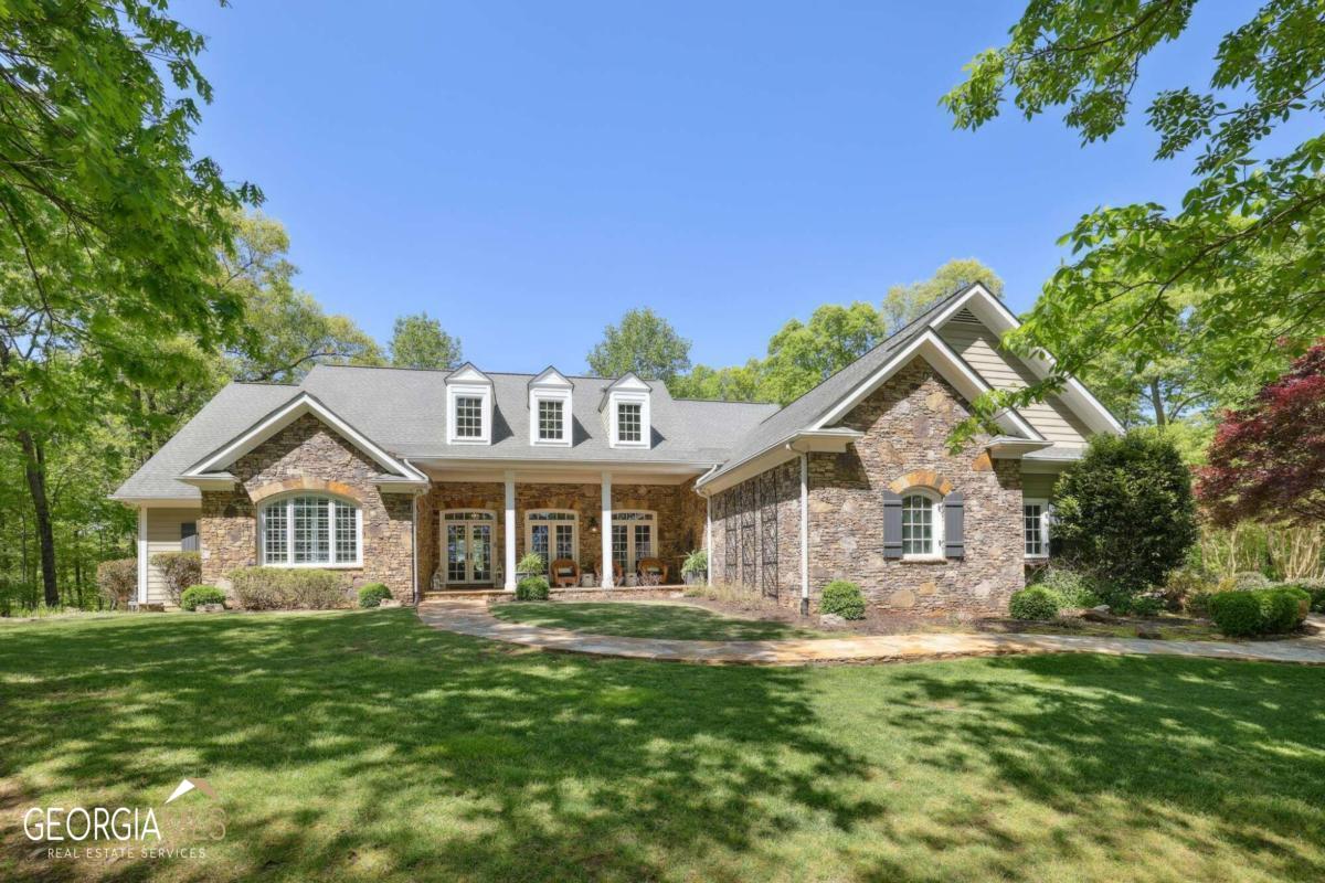 Nestled in the heart of Milton, this stunning home overlooks equestrian estates in one direction and the Blue Ridge mountains in the other. This home sits atop the highest elevation in Fulton County! The three-acre property has a gorgeous grass front yard, huge fire pit area and provides ample space and privacy with a wooded backyard, ensuring a peaceful and tranquil living experience. Upon entering the home, you will be greeted by large windows that provide an abundance of natural light and showcase the picturesque view of the trees bringing the outdoors in. The inviting foyer with a reclaimed wood accent wall leads to an updated dining area complete with a stack stone fireplace. The great room has another large fireplace flanked by beautiful open shelving and a jaw dropping chandelier. The gourmet kitchen features high-end appliances, custom cabinetry and reclaimed wood shelving, a large island perfect for entertaining, an Italian plaster hood over the stove, pot filler, and gleaming quartzite counters. The screened porch with yet another fireplace is the perfect place to relax after a long day! The primary suite on the main level has a separate vaulted seating area, huge closet, coffee bar and large bathroom. complete with a spa-like bathroom with access to the back porch. There are 2 secondary bedrooms on the main floor that share a hall bath, each with their own separate toilet and sink! The upper level includes an additional bedroom, ensuite bathroom and oversized bonus room Co perfect for guestCOs quarters, au pair suite, an amazing rec room or in-law retreat. The terrace level has a large family room with a fireplace, shiplap walls, bar area, pool room, a bedroom and beautifully updated bathroom with double vanity and the third car garage. There is also an enormous amount of unfinished space for future buildout or ample storage. This luxurious home offers the perfect combination of modern amenities and natural beauty, with its beautiful setting, spacious living areas, and high-end finishes. Don't miss the opportunity to make this exceptional property your own.