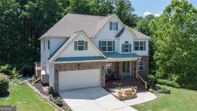 This custom-built home sits on a roundabout cul-de-sac nestled in the mountain side of Hampton Subdivision conveniently located just off Hwy GA 400. This home has many upgrades and several favorable features. Starting with the open, covered front porch, two story foyer as you step inside, highlighting a view to the formal sitting room, formal dining room and the family room. Hardwood floors flow throughout the main and upstairs flooring. This open floor plan provides a two story living room showcasing a stone fireplace with a custom wood mantel, custom floating shelving and cabinets, a full wall of windows, and plenty of room to entertain. A fully remodeled culinary kitchen offers; double oven, 5 burner gas stove-top with custom made vent hood and a pot filler, 3-foot sink, 7-foot custom table that seats 8, marble quartzite countertops with plenty of space to prepare a feast. A walk in pantry with metal shelving and a restaurant style (single saloon) swinging door meet every culinary aficionado's dreams. French door to the 50 foot deck that overlooks a wooded creek and lawn area. A generously large and versatile bonus room on the main floor with remodeled half bath can be used as office, living or bedroom space. The oversized laundry on the main with a wall of metal shelving, provides plenty of room for storage. The 2 car garage provides easy access to the kitchen and laundry storage area and has a 60 amp EV electrical charging unit run to interior wall. The exquisite Owners Suite oasis awaits your very own private getaway. Owners Bathroom invites you with a jacuzzi tub, spacious tiled shower, mind blowing cabinets and countertop space with double vanity that walks you into the 2 room walk in closet. All 3 secondary bedrooms provide double door closets and tray ceilings. Lots of fun to be had in the basement that features: stained concrete flooring throughout, a game room, sitting room, full bedroom with private sitting/TV area, walk in closet and full bathroom, 2 separate storage rooms, as well as 3 exterior door access to the 40-foot screened in porch. There is plenty of room to entertain with the built in bar that overlooks the lawn and wooded creek. The backyard has a lawn area and stone patio and firepit for entertaining and plenty of storytelling under the stars. Lined with a layer of trees, this back yard provides plenty of privacy. This 6-bedroom 3 1/2 bathroom has been meticulously maintained, with countless thoughtful upgrades throughout including a doggie door in the laundry room with private steps and invisible fence to keep your sweet doggies from leaving the property. The neighborhood is nestled in the mountains of Forsyth County with a one road entry and provides fiber/cable, clubhouse, swim/tennis, pickleball, volleyball, basketball, golf course, golf course restaurant, playground, park, neighborhood library box, sidewalks, streetlights, fishing pond and is conveniently located just off Hwy GA 400 (did I say that already), with award winning schools and just minutes away from North Georgia Outlets. Seller is married to listing agent/realtor.