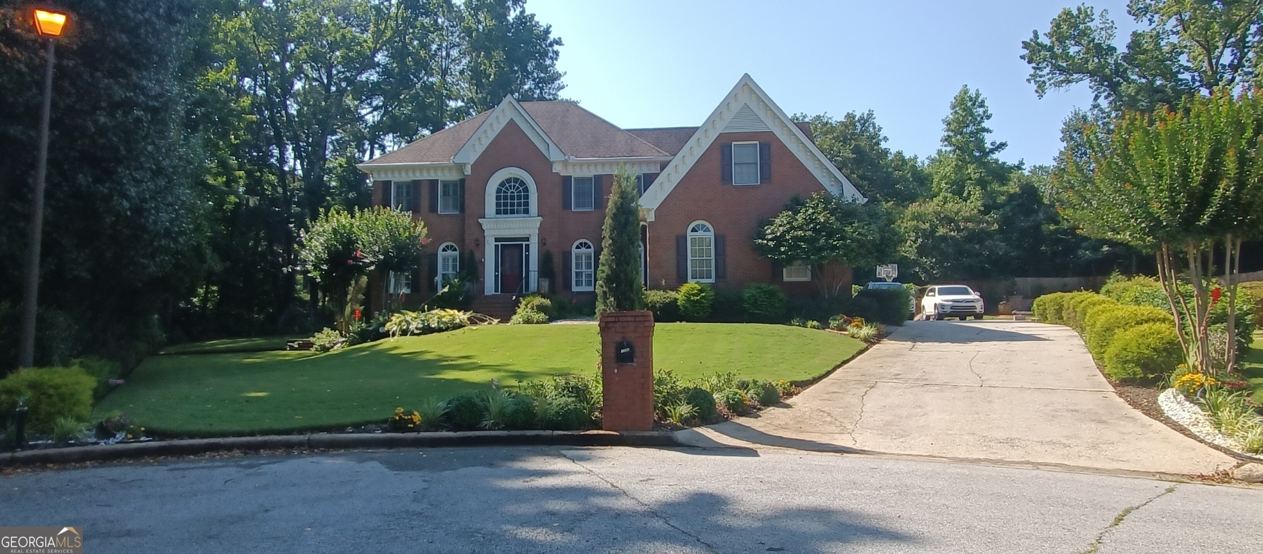 Gorgeous 7 Bedroom four-sided brick home in the highly sought-after Brookwood High School District and the Brookwood Manor Subdivision. The home is located on a cul-de-sac lot with a side entry garage. The property offers 7 bedrooms and 5 baths with an elegant 2-story foyer with vaulted ceiling and crown moldings, hardwood flooring on all of the main floor, a large, remodeled kitchen with top-grade granite countertops, a formal dining room and adjoining living room, and a first-floor bedroom that is currently used as a professional office. The spacious family/great room has a gas/wood-burning fireplace, a perfect view of a gourmet kitchen, elegant wood-finished walls, and a wet bar with a concealed sink. Adjacent to the family room is a large sunroom that leads to a deck that wraps around the bay windows of the breakfast nook. The walk-in laundry/mud room with utility sink sits off the hallway that connects the family room to the garage, and also leads to a half-bath. Upstairs are a spacious Master bedroom suite with a vaulted ceiling, double vanity, jetted whirlpool tub and separate shower, walk-in closets, a large secondary master/guest bedroom with a large walk-in closet, 2 additional bedrooms, and an exceptionally large full bathroom. The fully finished basement that has its own exterior access and patio has 2 additional bedrooms, a media/fitness room, a library, and storage areas with bike racks and ample shelving. The grounds, which are great for entertaining, have large front, side, and back level lawns surrounded by Green Giant Arborvitae and Leyland Cypress privacy trees, flower beds that are stocked with perennial flowering plants and shrubbery, a custom built and exquisite large raised circular paver patio and fire pit with fixed structural concrete seating with paver facade that can seat about 8 people, and electric lights, and outlets/charging stations, and a separate patio for parking a trailer. The Brookwood Manor subdivision has its own gated, competition-grade Tennis court and swimming pool, playground (access to the recreation areas available by joining the voluntary/optional HOA), and is a few minutes' walk to Brookwood High School and Brookwood Elementary, and has close proximity to shopping centers (Walmart, Sam's Club, Target, Home Depot, Lowes', Publix, etc.), restaurants, library, hospital, medical facilities, public parks, and highways. Welcome to your new home!